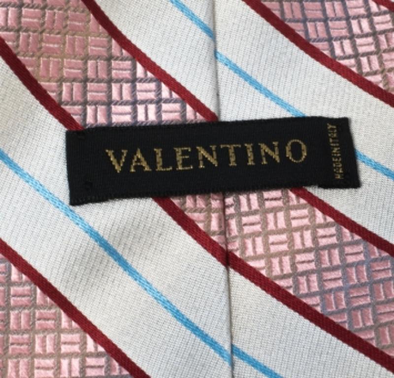 This Valentino tie is a perfect formal accessory that has a sharp and modern appeal. Made from silk, it features white and pink shades, diagonal stripes, and the brand label neatly stitched at the back. It is sure to add oodles of style to your