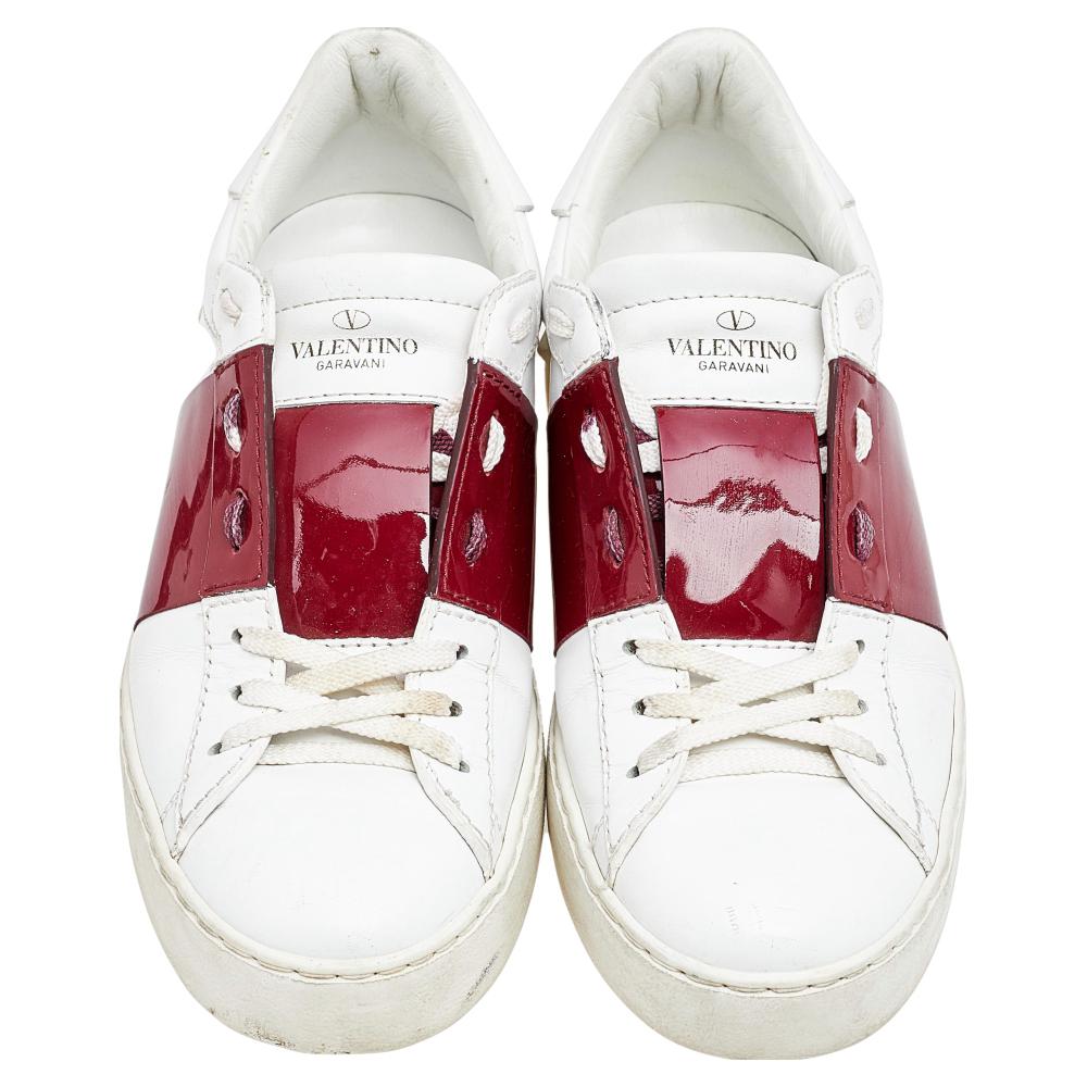 Experience signature style without compromising on comfort as you wear these Rockstud sneakers from the House of Valentino. They are made from white-red leather and patent leather with a lace-up detail highlighting their vamps. These low-top