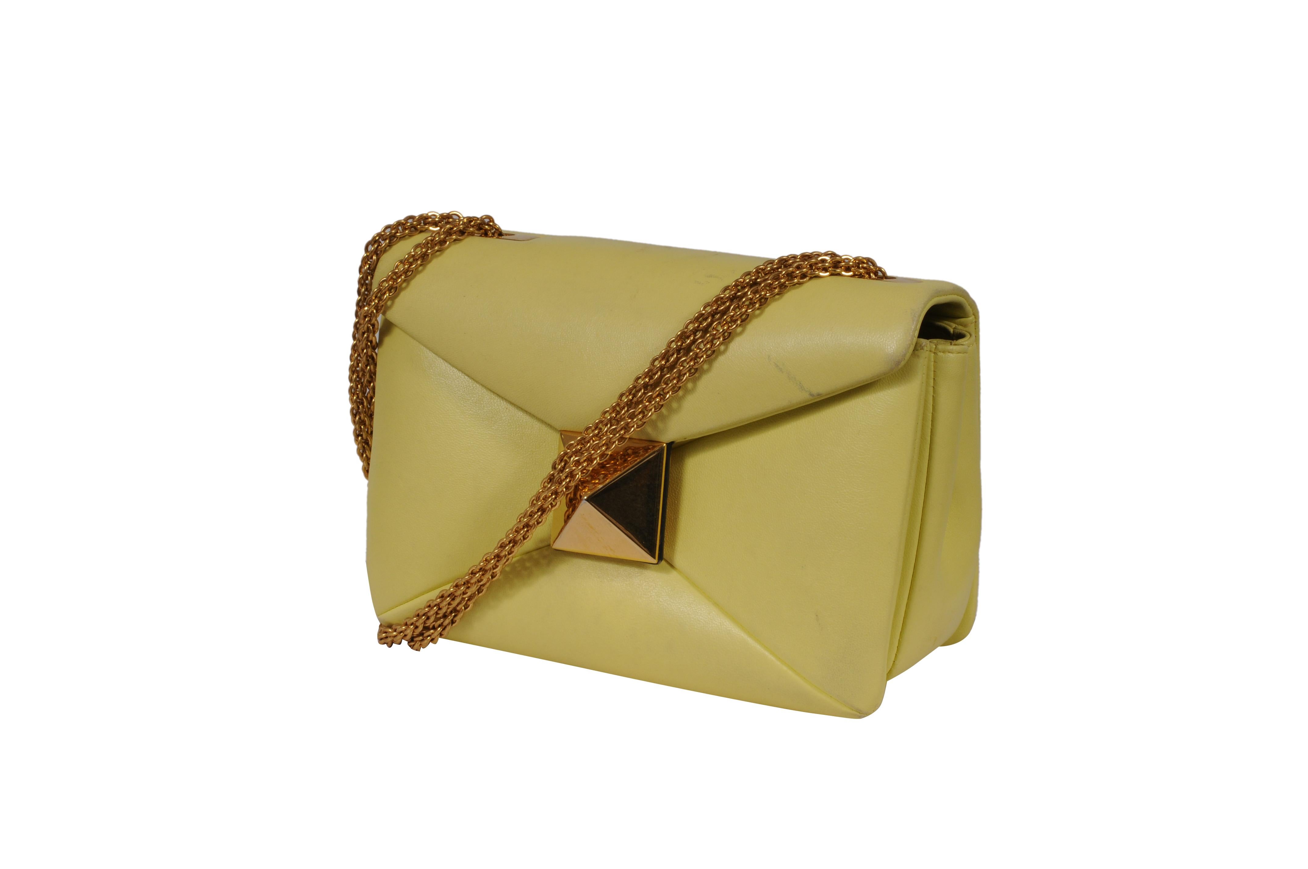 - Extérieur jaune



- Bracelet en métal doré



Condit : 



Le sac est en très bon état et ne présente pas d'imperfections majeures. 



Mesures : ( Approximativement en pouces ) 



 5 H x 7.8 L x 3.9 L. 