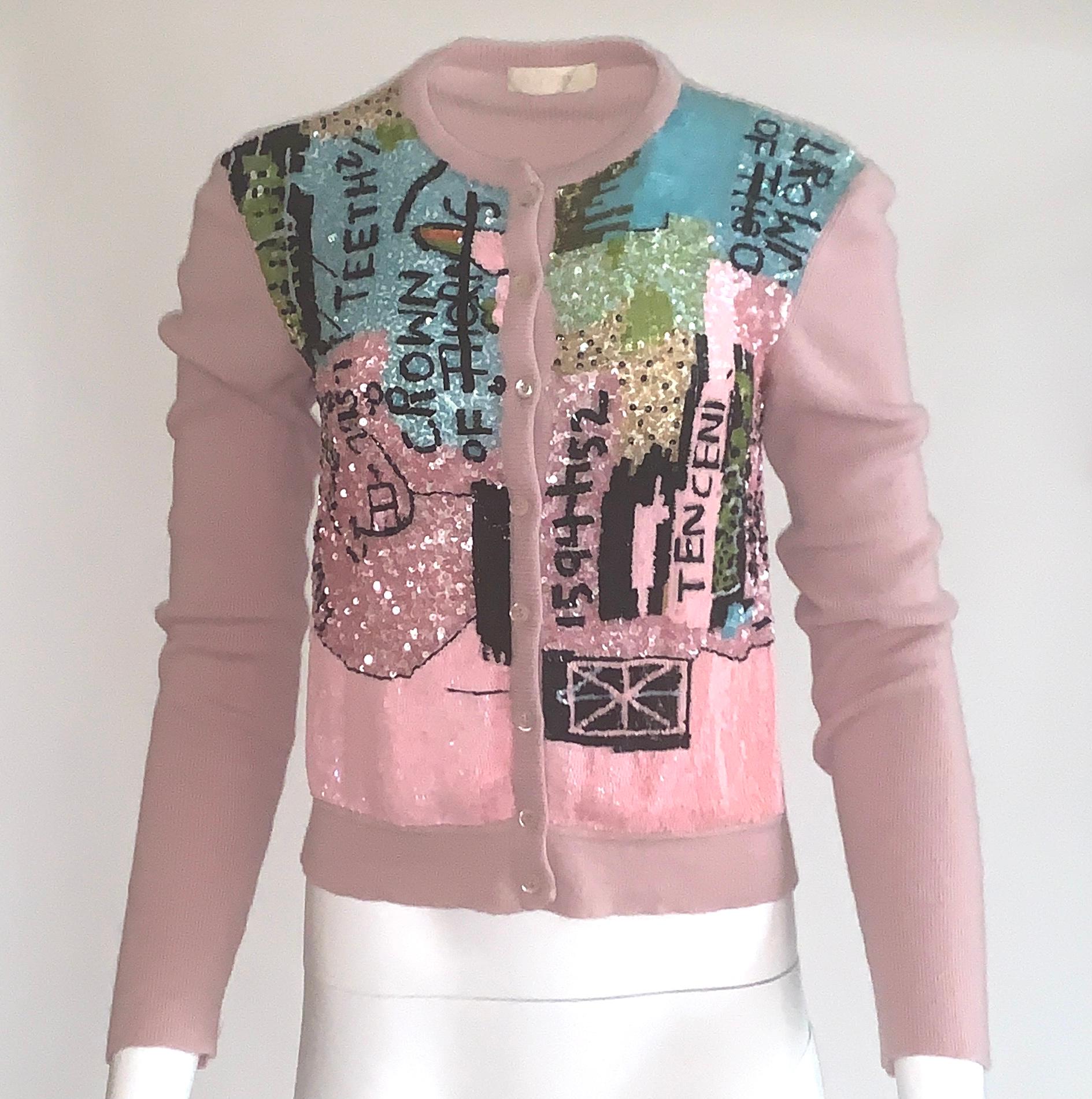 Amazing and rare mauve pink rib-knit wool-cashmere cardigan from the 2006 Valentino collection created with Basquiat prints. Front sweater is covered in pink, black, robin's egg and lime sequins creating an iconic Basquiat work. Long sleeve, button