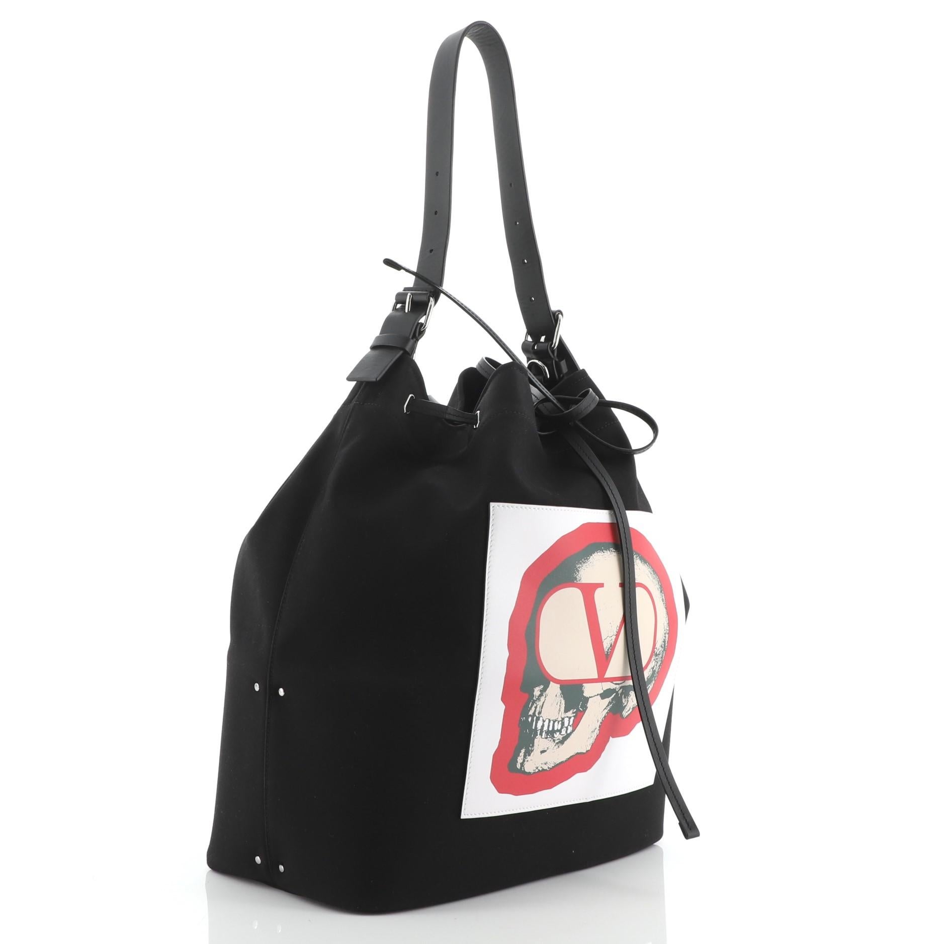 Valentino x Undercover Bucket Bag Printed Nylon
Black

Condition Details: Odor in interior. Minor wear, discoloration and marks on exterior, light scuffs and creasing on handle and strap. Creasing on pochette, scratches on