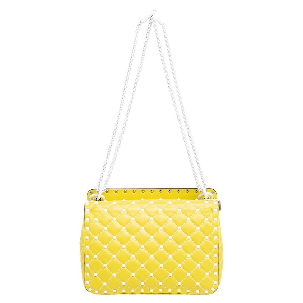 Let Valentino's fashion-forward aesthetic be the highlight of your look with this Rockstud Spike bag – note how the studs shine against the yellow quilted leather. Crafted in Italy, it is perfectly shaped to easily house your everyday essentials and
