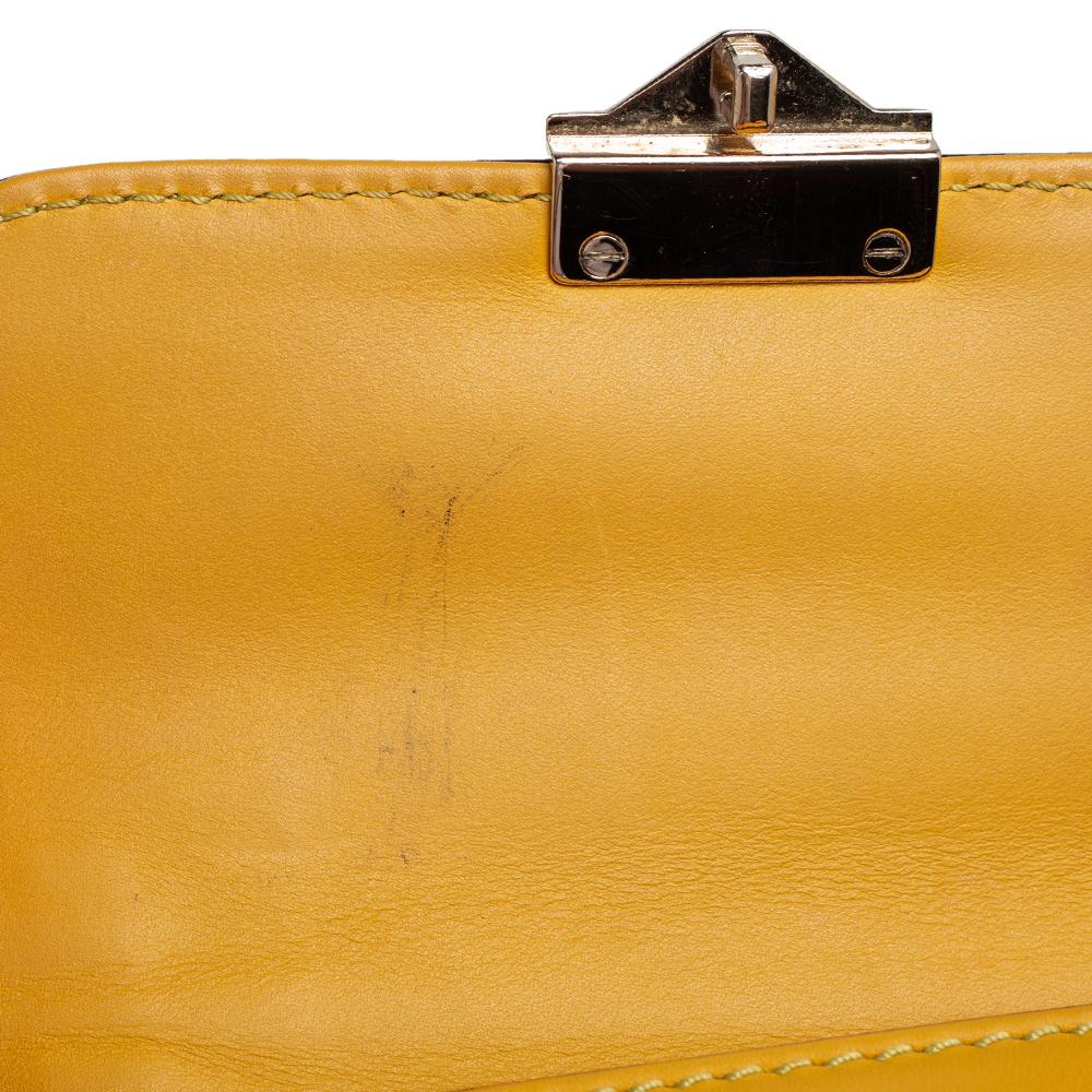 This striking yellow bag from Valentino comes with the iconic Rockstud trim. Made in Italy the bag is crafted from leather and has a fabric-lined interior with a slip pocket. It has gold-tone hardware and a push-lock closure. Perfect for a night out