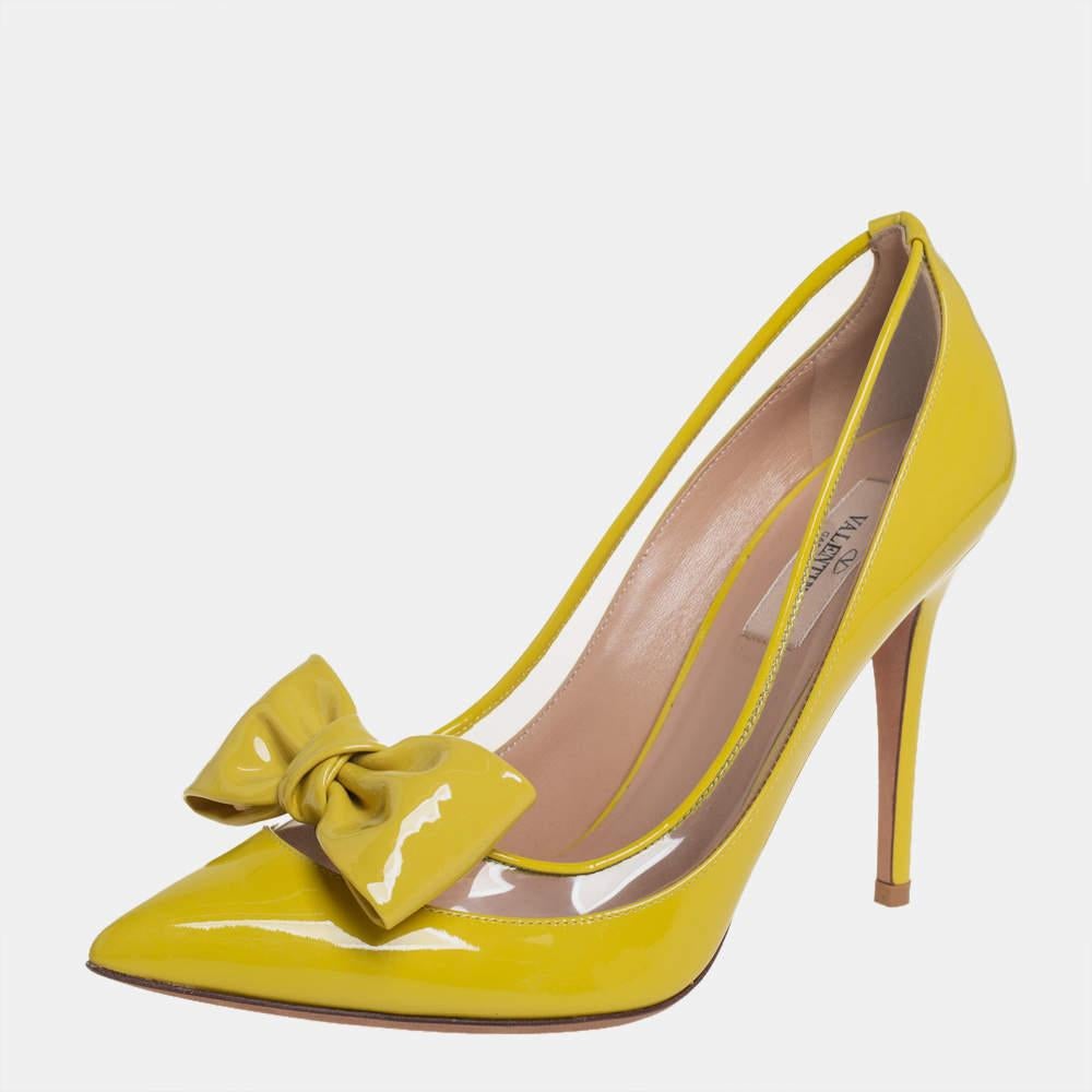 Elegance and feminine grace are what these Valentino pumps are all about! The yellow beauties are crafted from patent leather and feature pointed toes. They flaunt stylish bows on the vamps and come equipped with comfortable leather-lined insoles,