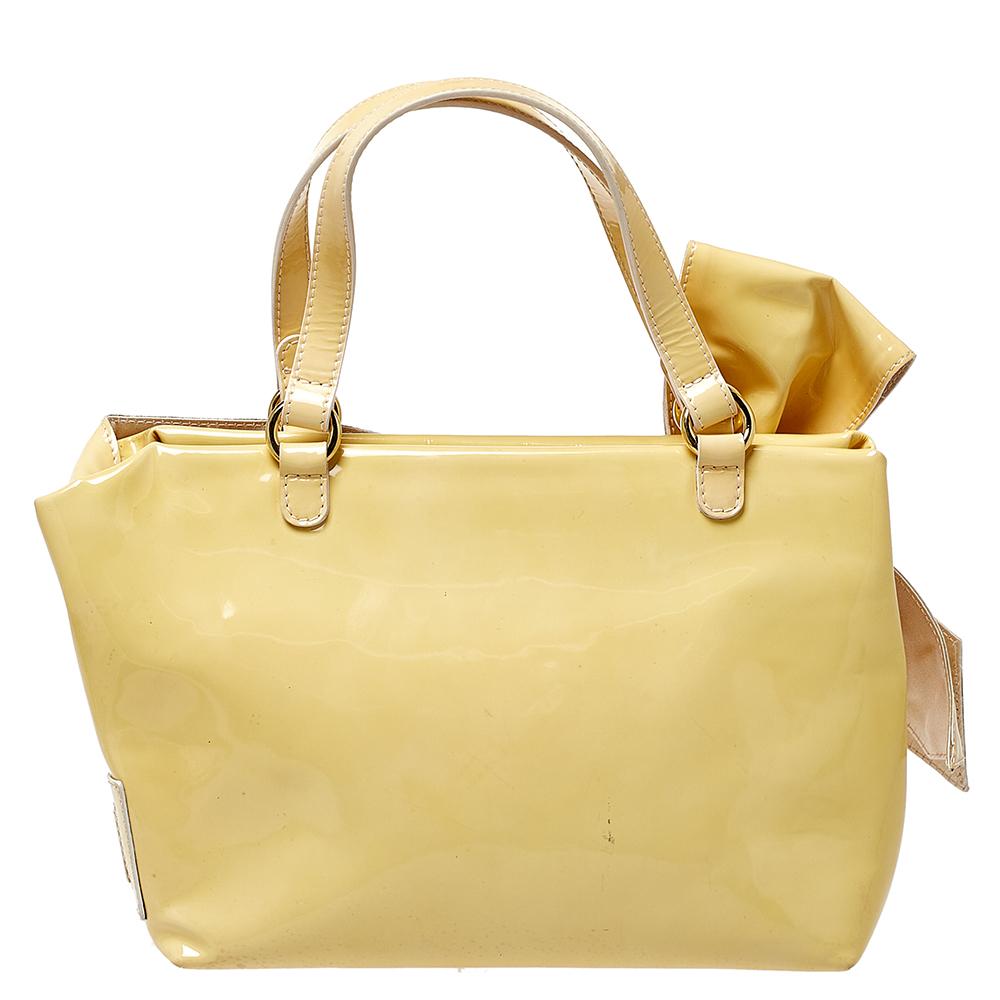 Set in a contemporary design and style, this tote from Valentino is absolutely mesmerizing. The lovely tote is crafted from smooth patent leather and features beautiful bow details on the front. It comes with dual top handles, a spacious satin-lined