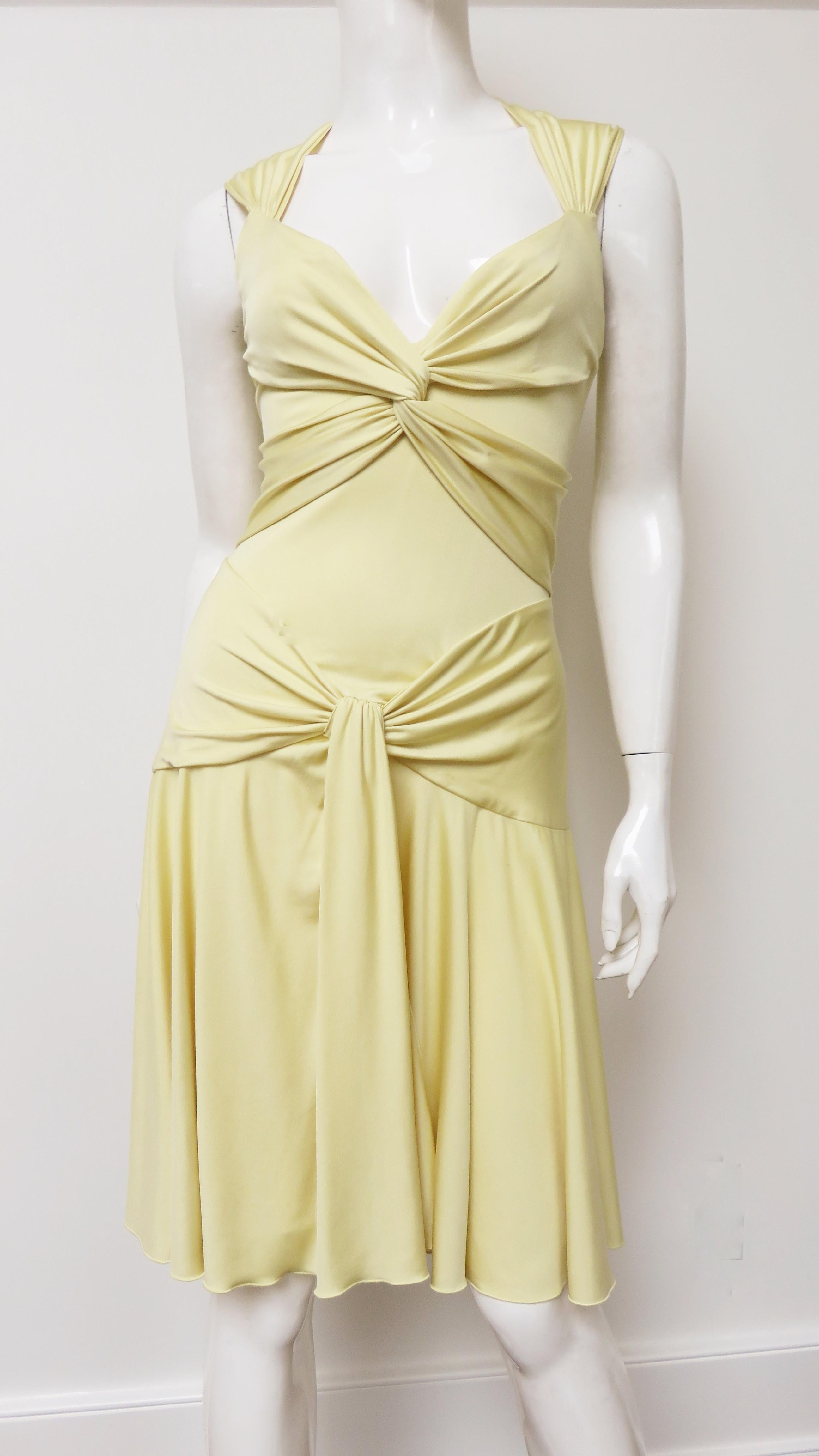 A gorgeous yellow fine silk knit dress by Valentino. It is semi fitted, sleeveless with a V neckline and ruched panels across the bust and hips. The skirt is full and slightly longer in the back, the dress has a back zipper and is unlined
Fits size