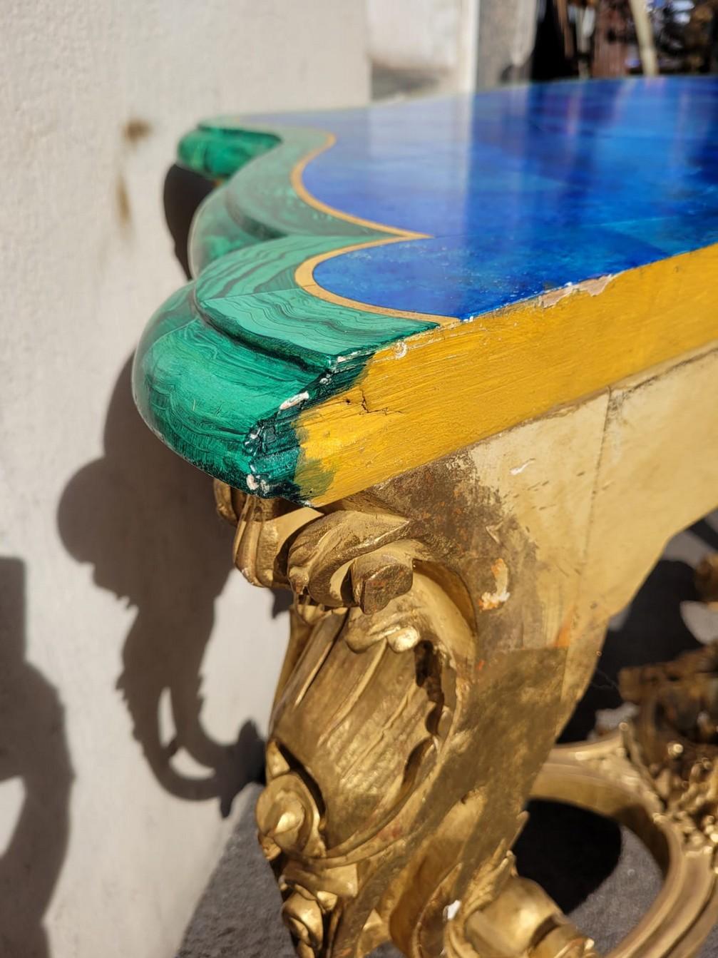 Beautiful and large Rococo console in gilded wood, with a faux-lapis and malachite painted top.

This console table is attributed to Valérian Rybar, a great 20th century decorator and known as 