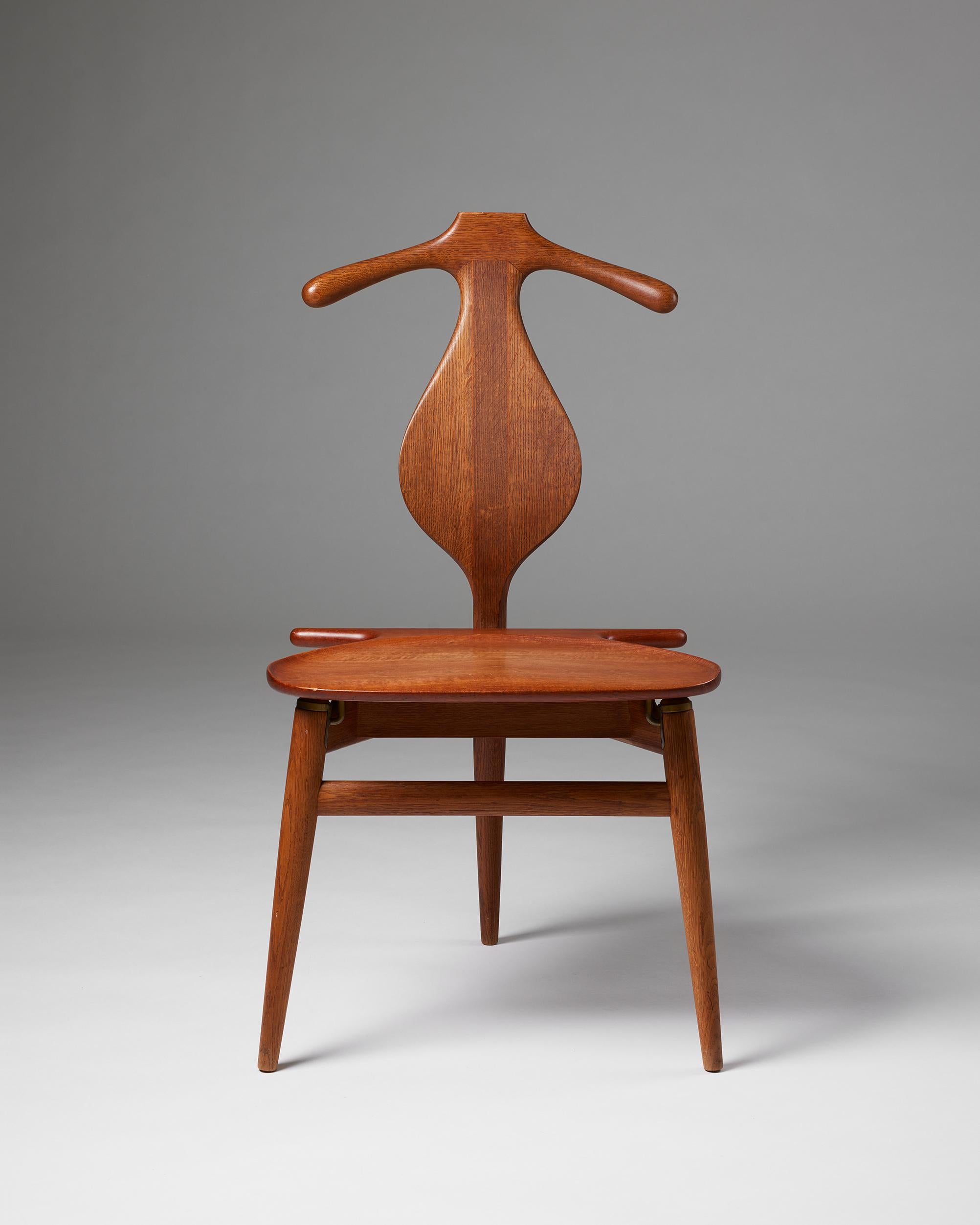 Valet chair model 540 designed by Hans J. Wegner for Johannes Jansen,
Denmark, 1953.

Teak, oak and brass.

Stamped.

H: 94 cm
W: 51 cm
D: 50 cm
SH: 44.5 cm

Hans J. Wegner is the father of Danish design and is well known for creating
