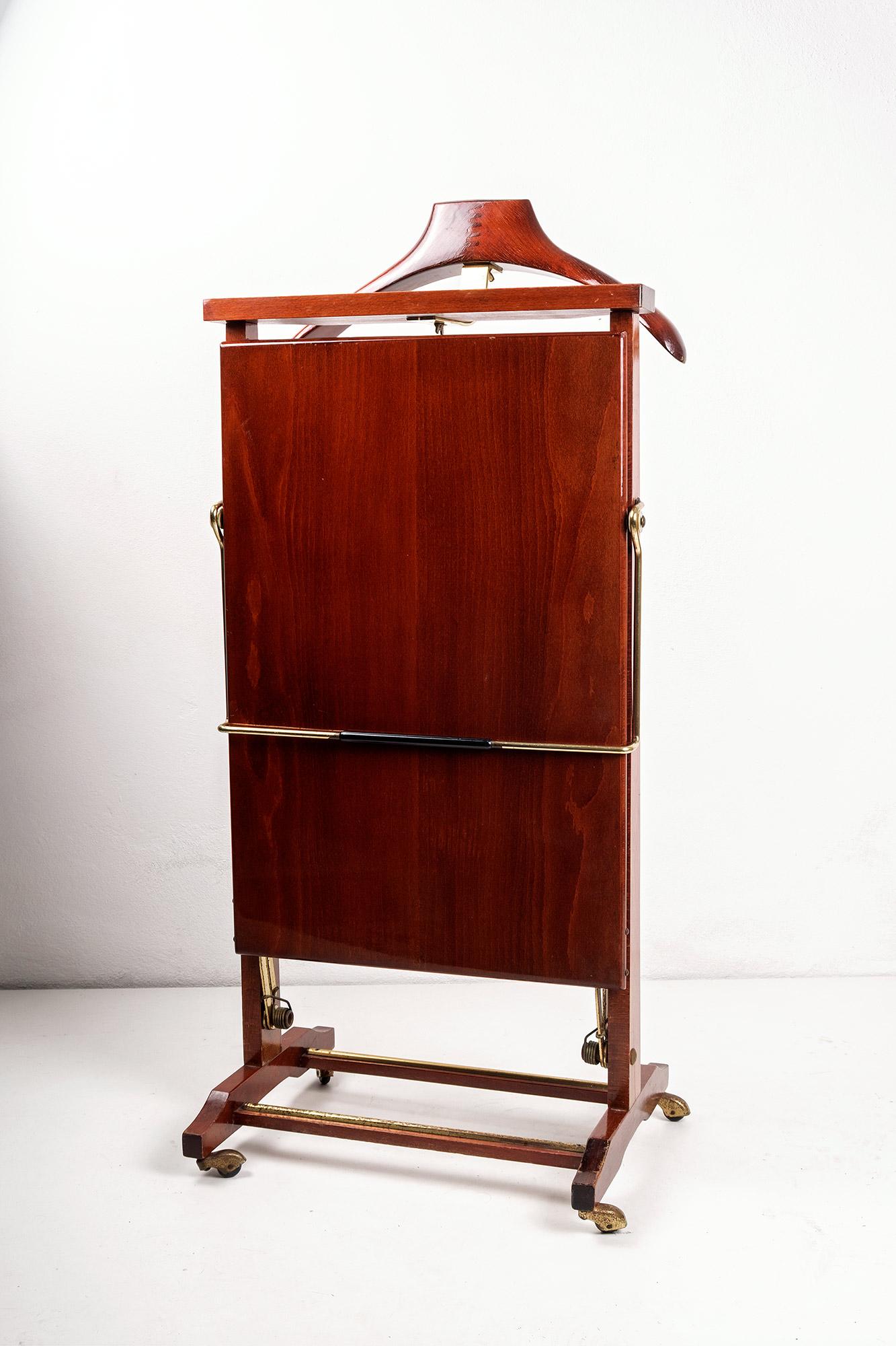 Beautiful valet stand and trouser press by Ico and Luisa Parisi for Fratelli Reguitti, Italy. 
Executed in a splendid lacquered walnut with brass inserts. 
Remainings of an instruction label on the inside.