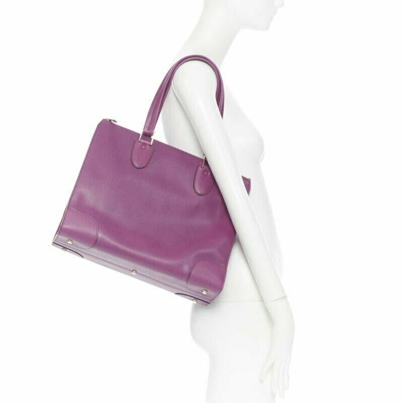 VALEXTRA purple leather dual top handle gold hardware top zip structured bag 
Reference: LNKO/A01246 
Brand: Valextra 
Model: Top zip tote 
Material: Leather 
Color: Purple 
Pattern: Solid 
Closure: Zip 
Extra Detail: Gold-tone hardware. Dual flat