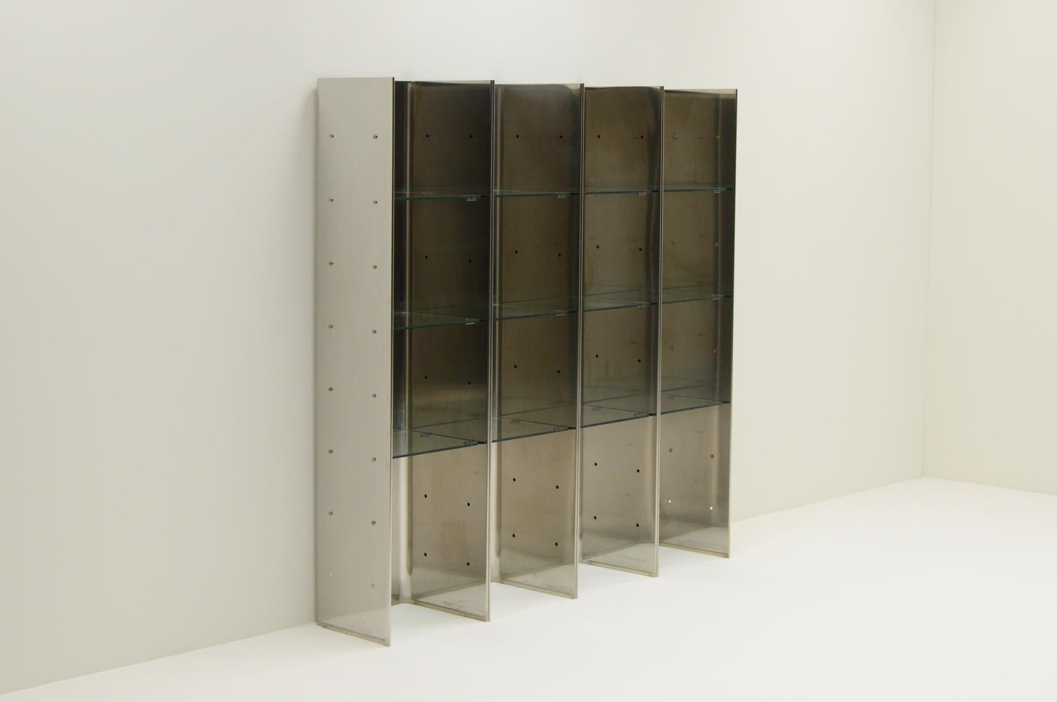 Rare Valiant bookcase from Carla Venosta & Guido Zimmerman for Arflex, 1970s Italy. This is a modular free standing system, that also can be used as room devider. 4 stainless steel shells that connect together and glass shelves. One shell has some