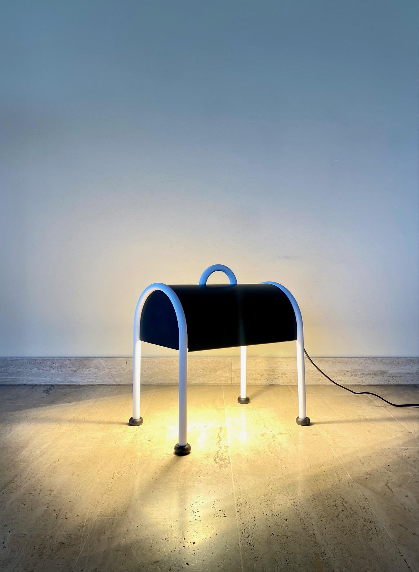 Lampadaire ou lampe de table Valigia de Sottsass pour Stilnovo, 1970

Lampe de table ou lampadaire Valigia avec structure tubulaire en acier tubulaire peint en blanc. 
L'abat-jour en tôle est bicolore, avec un extérieur noir opaque et un intérieur