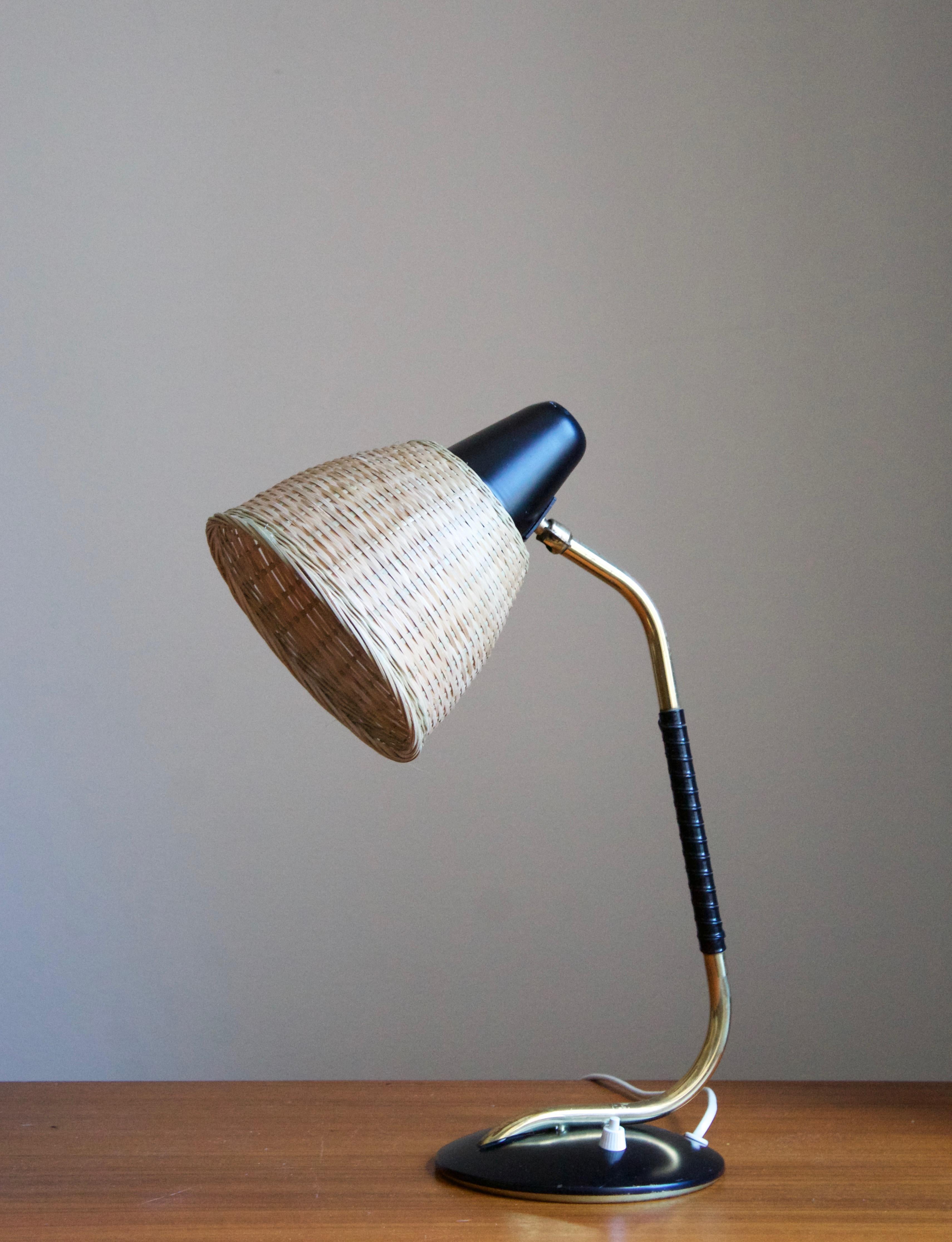 A table lamp or desk light by Valinte Oy. In brass, lacquered metal, rubber, and with an assorted vintage rattan lampshade. Stamped

Other designers of the period include Josef Frank, Paavo Tynell, Hans Bergström, Böhlmarks, and Jean Royère.