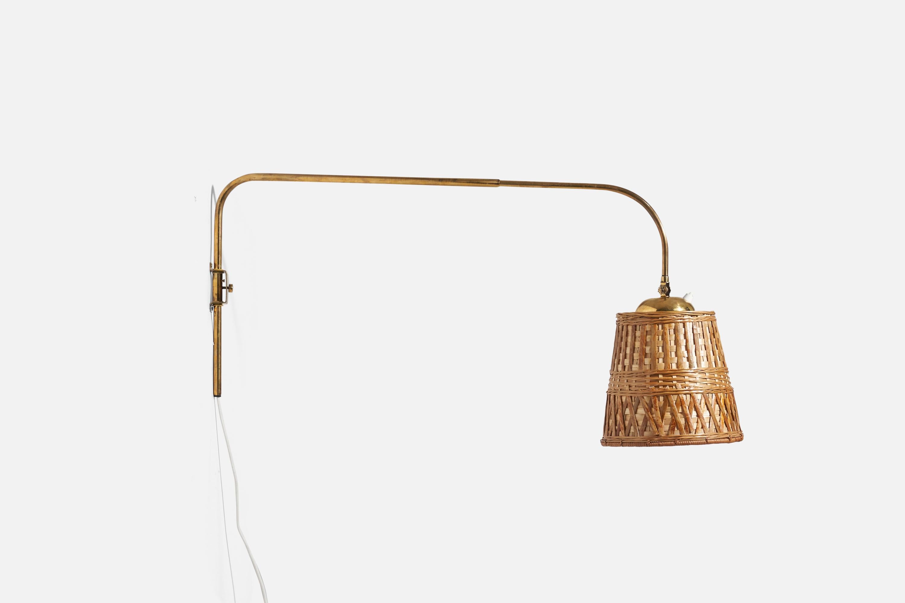 A brass and rattan wall light designed and produced by Valinte OY, Finland, 1950s. 

Dimensions variable, measured as illustrated in first image.

Sold with Lampshade. Dimensions stated are of Sconce with Lampshade.

Socket takes standard E-26