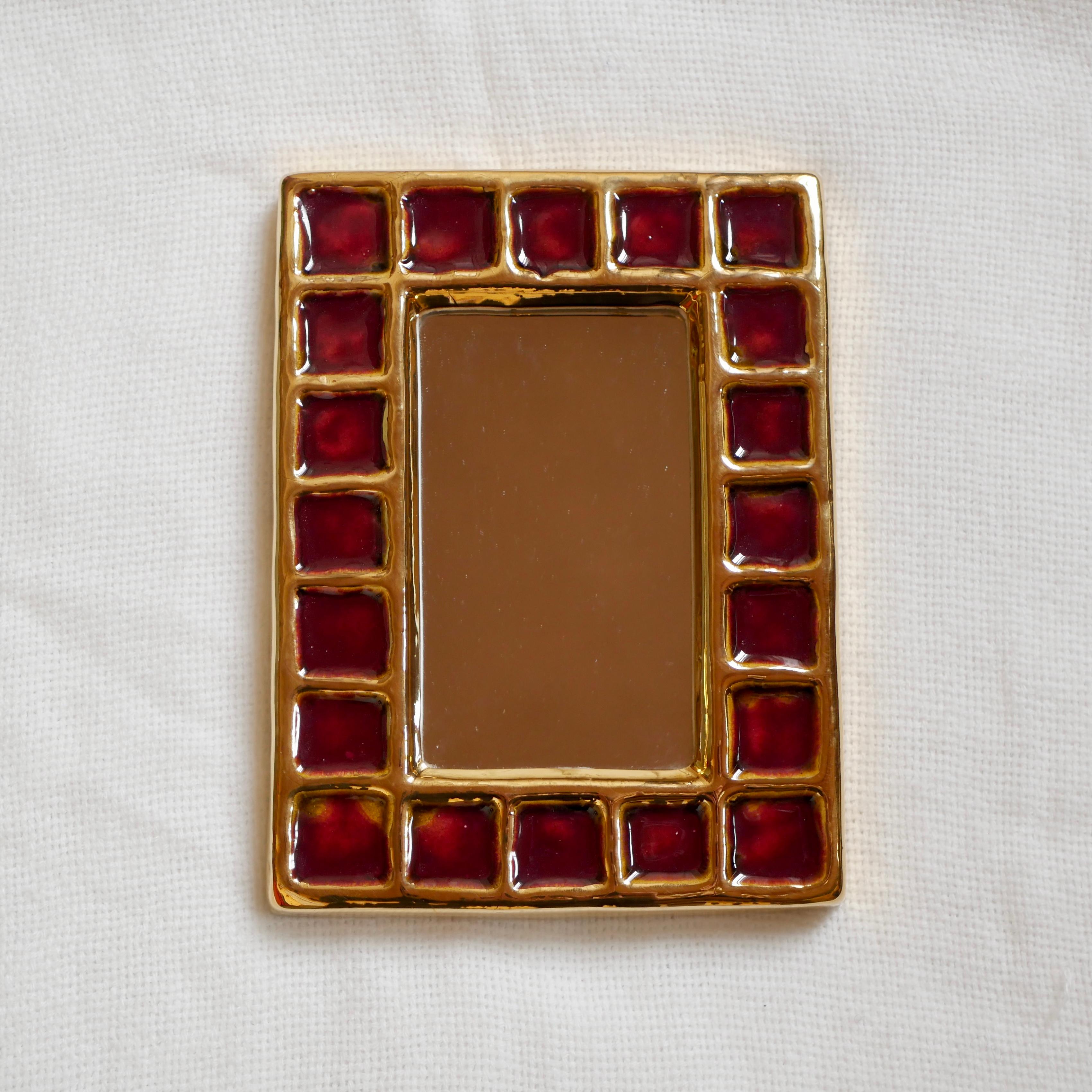 Magnifique miroir en forme de bijou de François Jewell, réalisé dans les années 1960 dans son atelier de Vallauris.
Carrés rouge et or, excellent état.
Avec la signature emblématique au dos.

François Lembo est né à Vallauris et a commencé sa