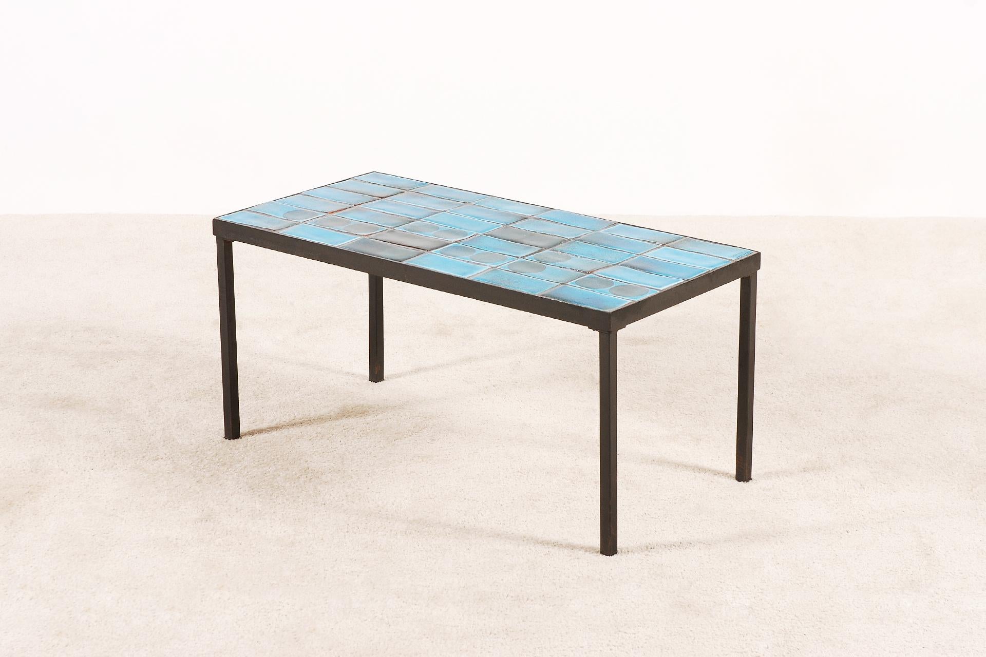 Coffee table designed by the French ceramists Almone (Alain + Simone), circa 1960.
The top is made of very nice blue ceramic tiles and the frame is in black lacquered metal.

The table is signed by Almone + Vallauris in a corner.