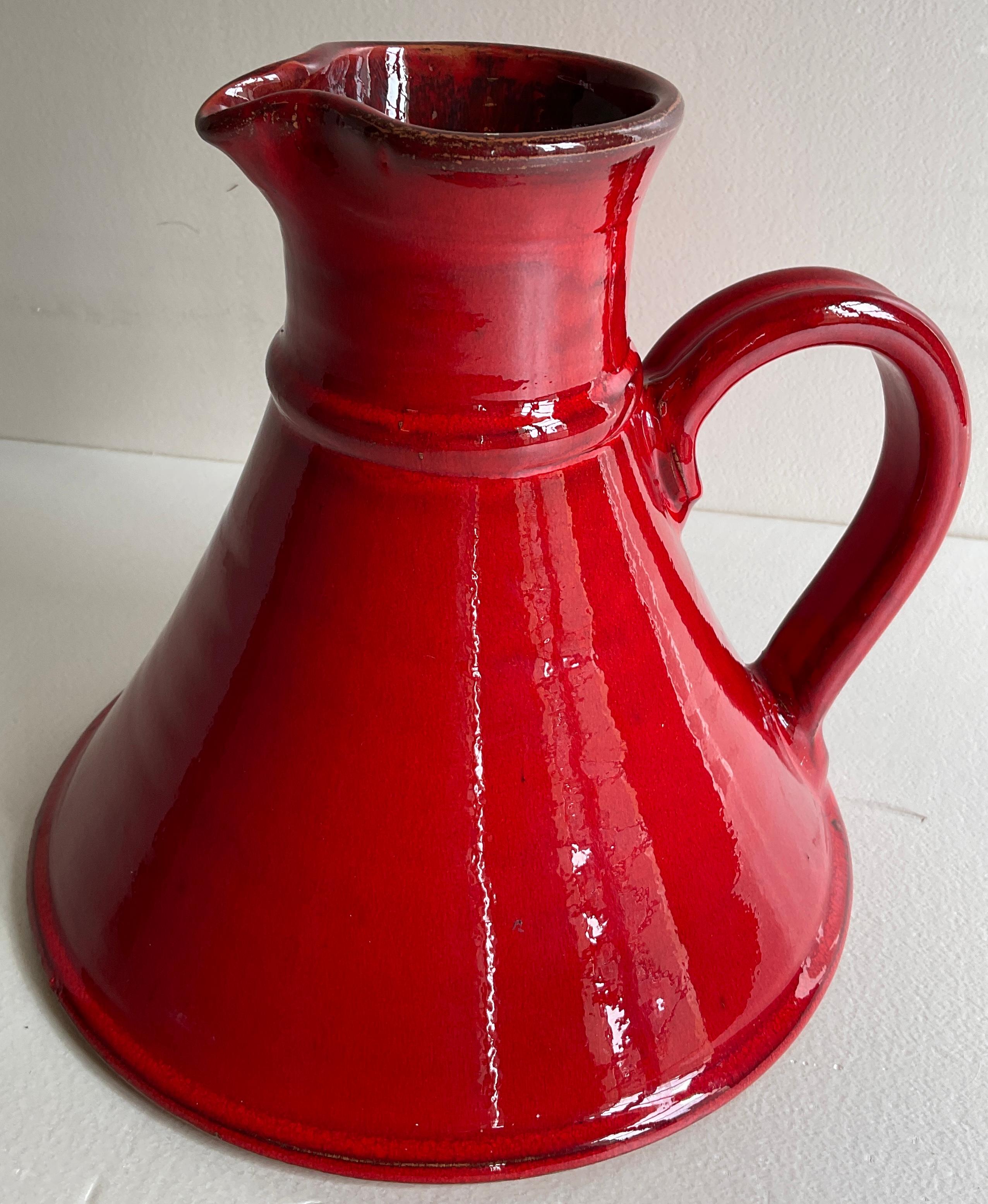 A very collectable mid-century vintage handled vase or pitcher. This decorative piece has classic modernist simplicity.

A rich red glazed finish makes this piece particularly interesting and pleasing to the eye. 

Measures: 7 1/2