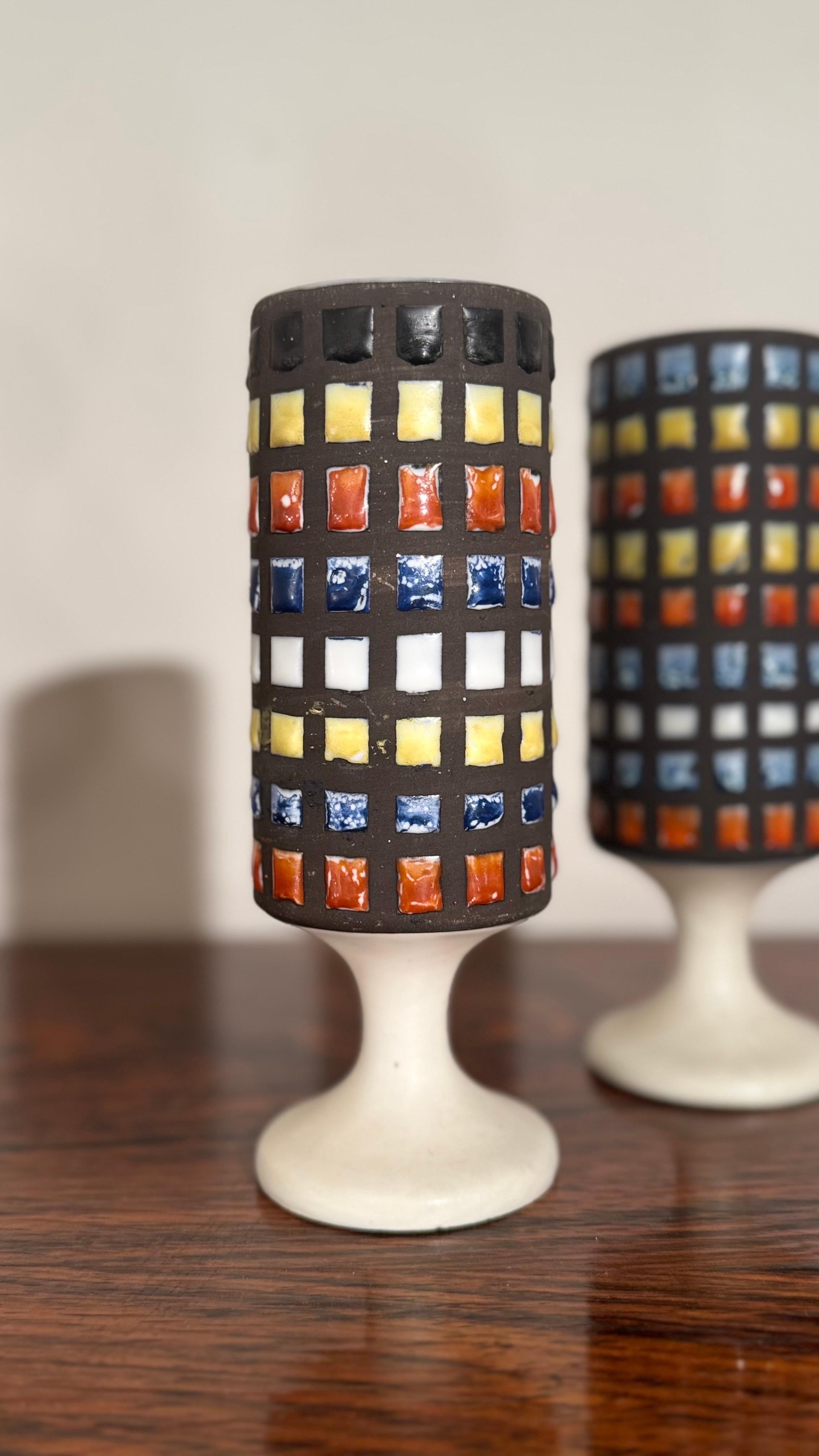 Modern ceramic goblets, vases white mat glazed and an abstract décor in shades of white, blue, yellow, and red, outlined with black lines. The result is an almost architectural effect, characteristic of Capron’s modernist and decorative style.  A