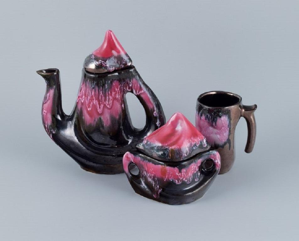 Vallauris, France, coffee pot, lidded bowl and a coffee mug. Luster glaze.
1960/70s.
In good condition with an insignificant small chip on the spout.
Marked.
Coffee pot measures: H 26.0 x D (including handle and spout) 23.0 cm.