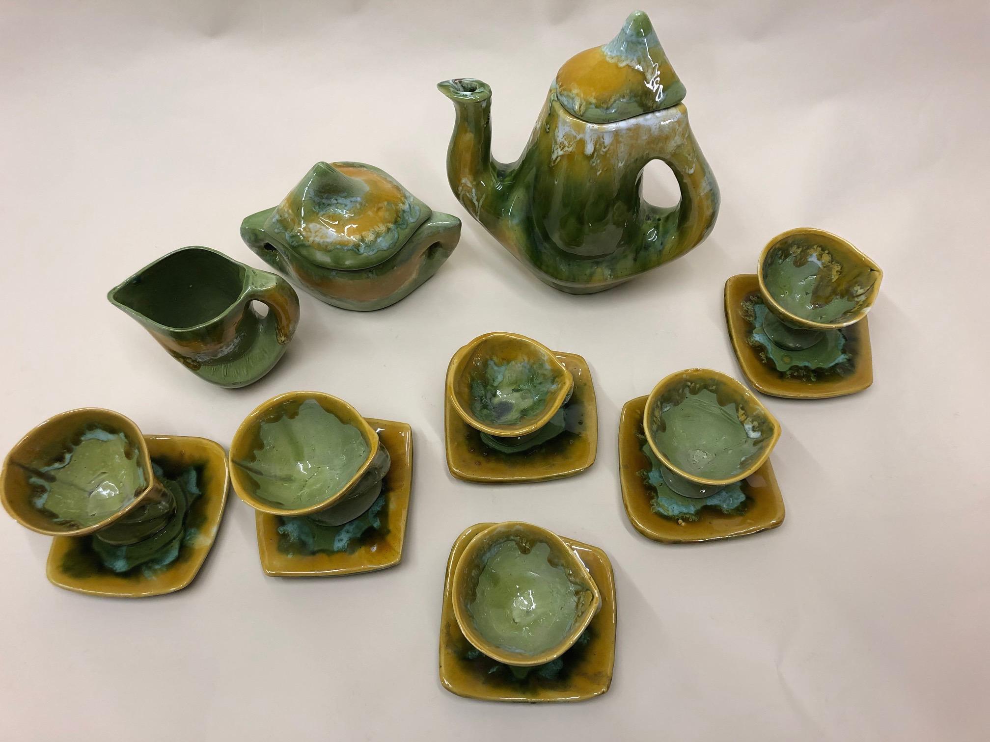 Fabulous design of a luscious green and oker yellow Vallauris ceramic coffee set.
This contemporary and complete set has a coffee pot, sugarbowl, creamer and six cups and saucers. The set has been made in the 1960s.
The 9 piece set is a rich hand