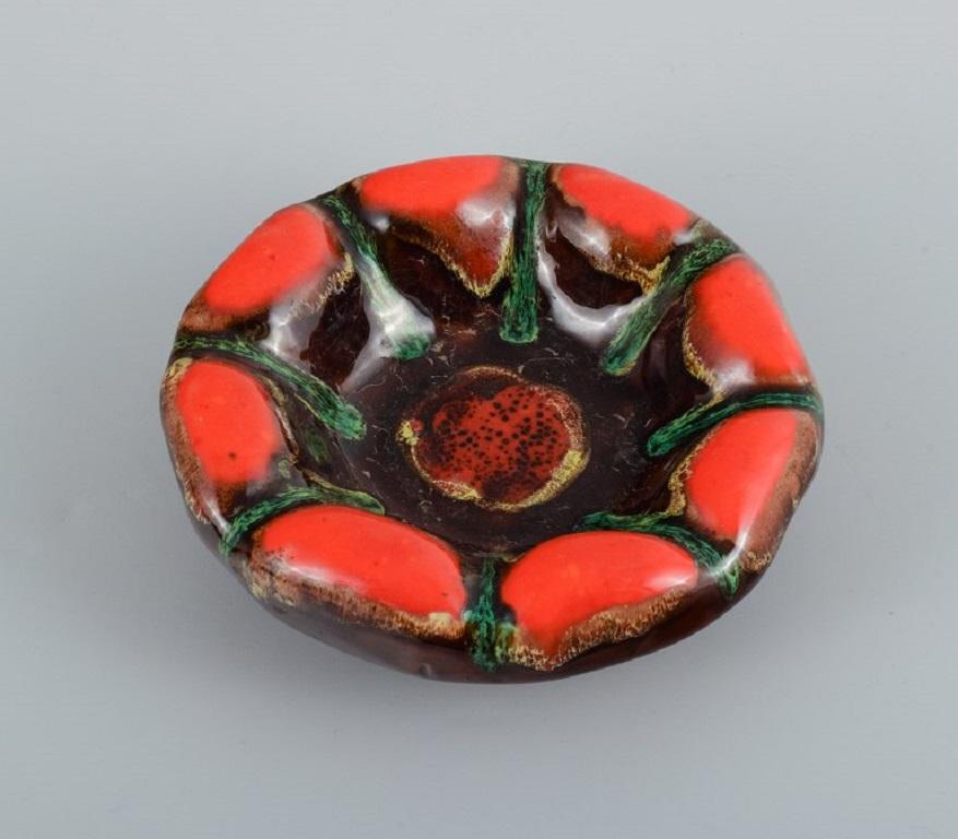 Vallauris, France, three ceramic bowls in brightly colored glazes in red and green on a dark base.
1960/70s.
Marked.
In excellent condition.
Largest measurement: D 18.5 x H 6.0 cm.
 