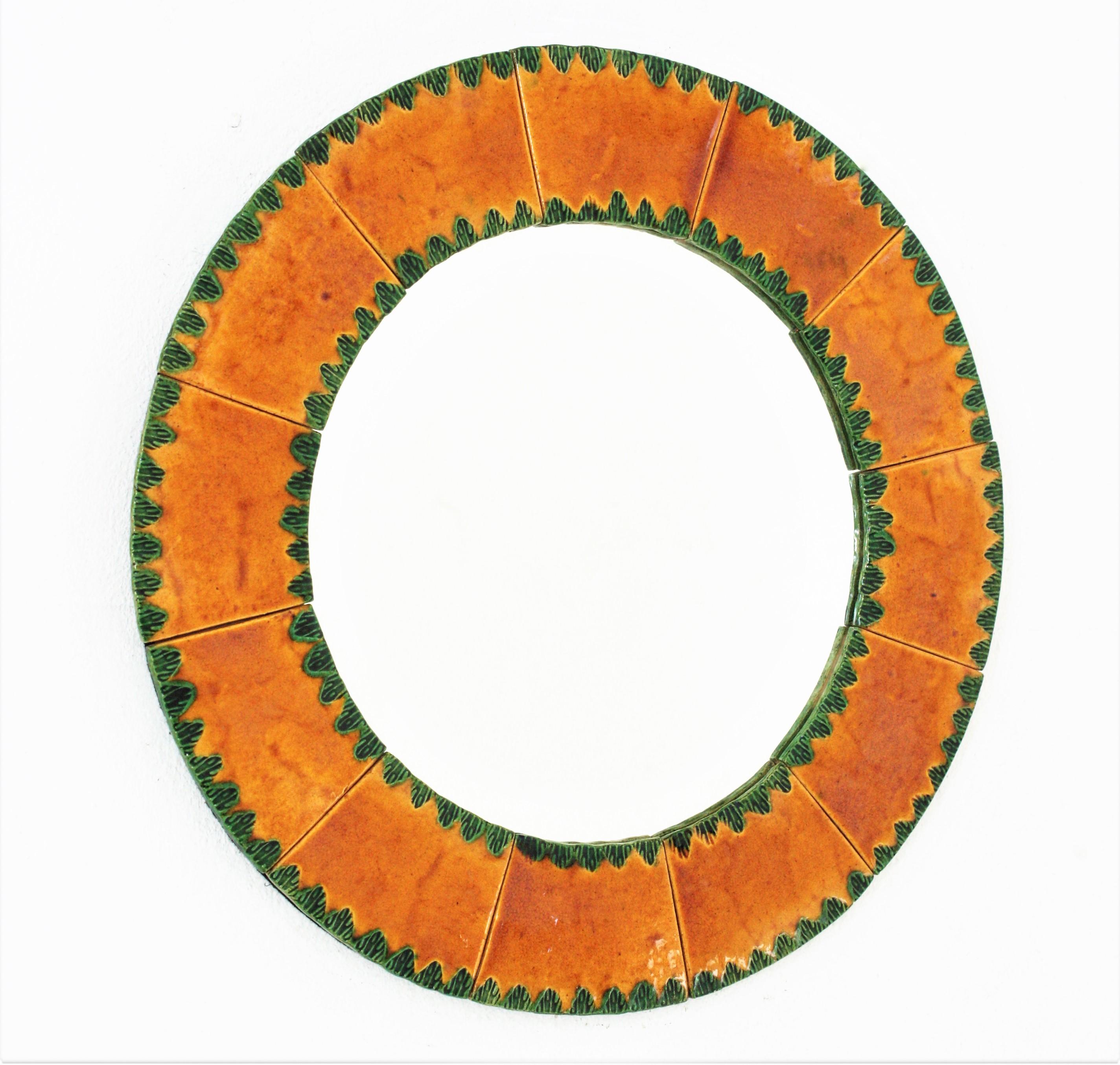 Midcentury orange and green glazed ceramic round mirror . France, 1960s
The frame features a mosaic of large orange ceramic tiles with leafed patterns in green ceramic.
This pretty beautiful ceramic mirror with naturalistic motifs will be the