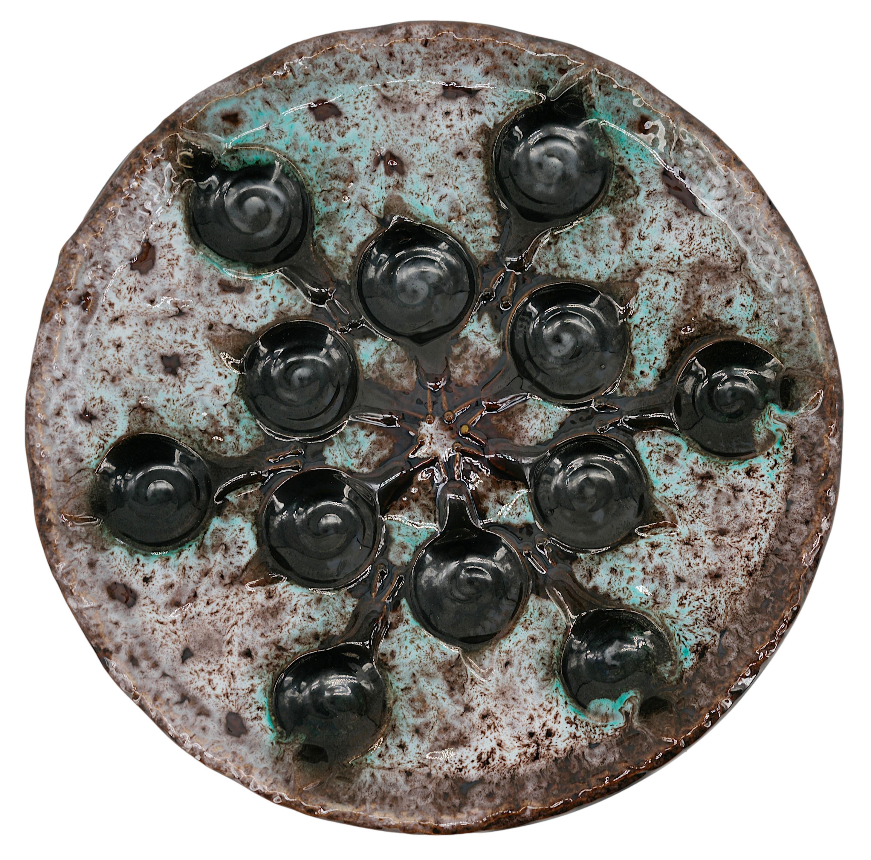 Ensemble d'escargots en céramique du milieu du siècle dernier par Marius GIUGE à Vallauris, France, années 1960. Ensemble composé d'un plat et de 8 assiettes.  Dimensions : Plat - Largeur : 28.3cm - 11.15 inches, Diamètre : 3.9cm - 1.54 inches ;