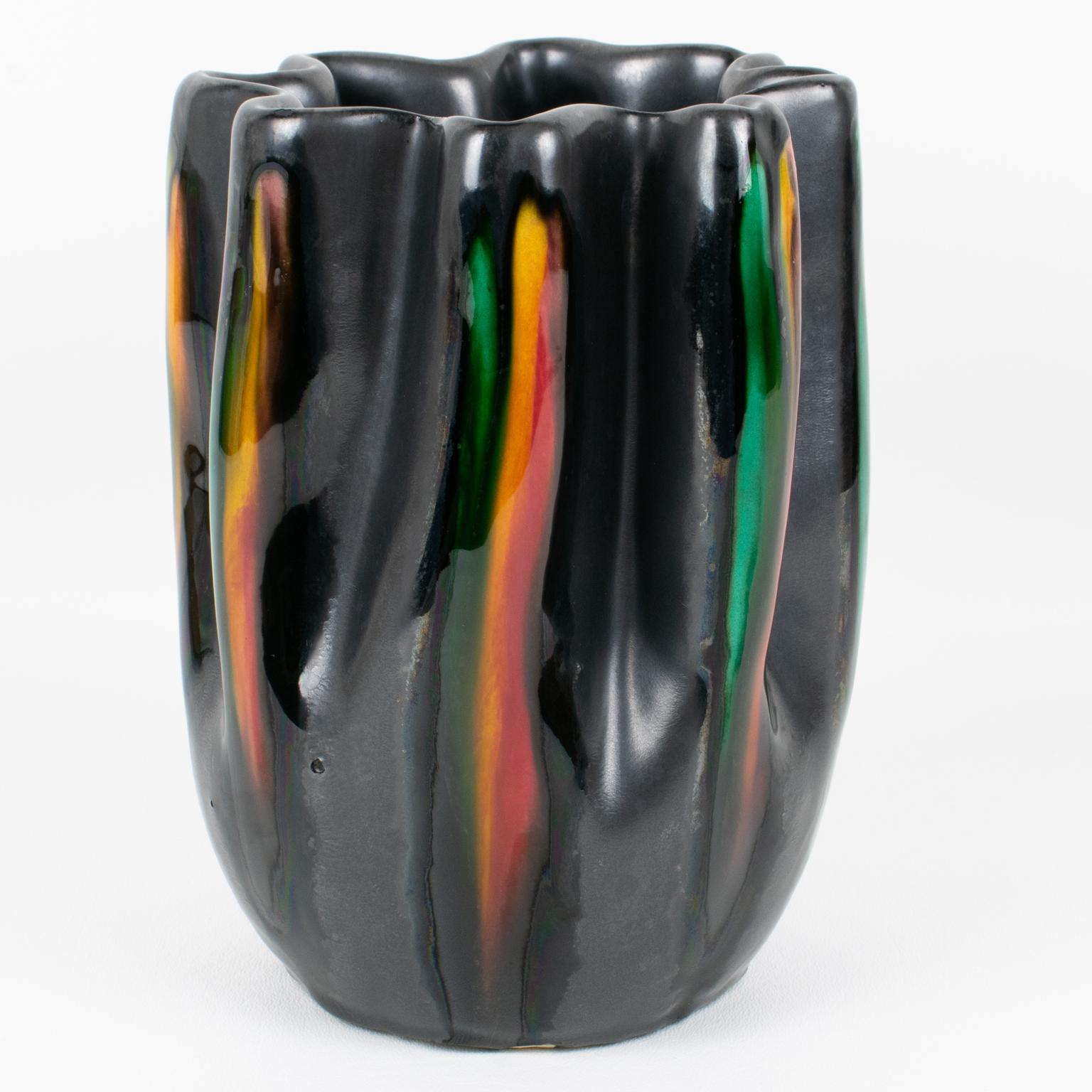 Questo superbo vaso in ceramica modernista del Mid-Century è stato realizzato a Vallauris, in Francia, intorno al 1950. La forma smerlata ha un motivo unico creato da gocce di colore contrastate da uno smalto nero profondo. L'opera vanta una