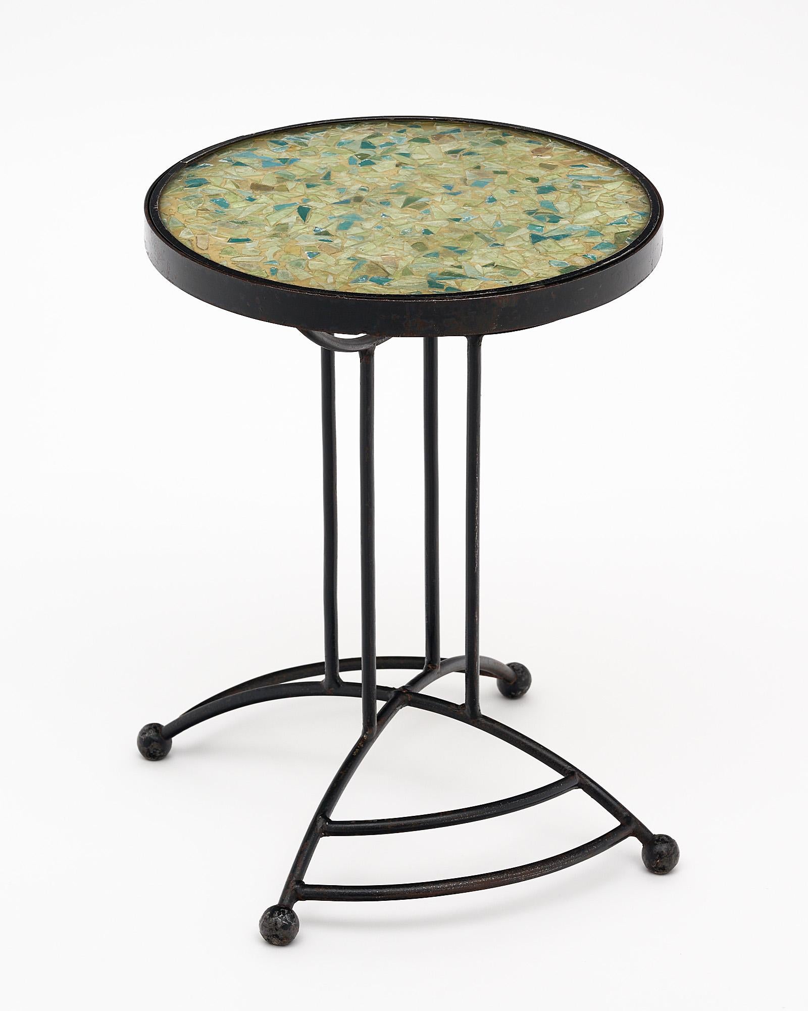 Side table, French, from Vallauris on the French Riviera. This modernist intricate black lacquered iron base supports a spheric top featuring an original polychrome glass mosaic work.