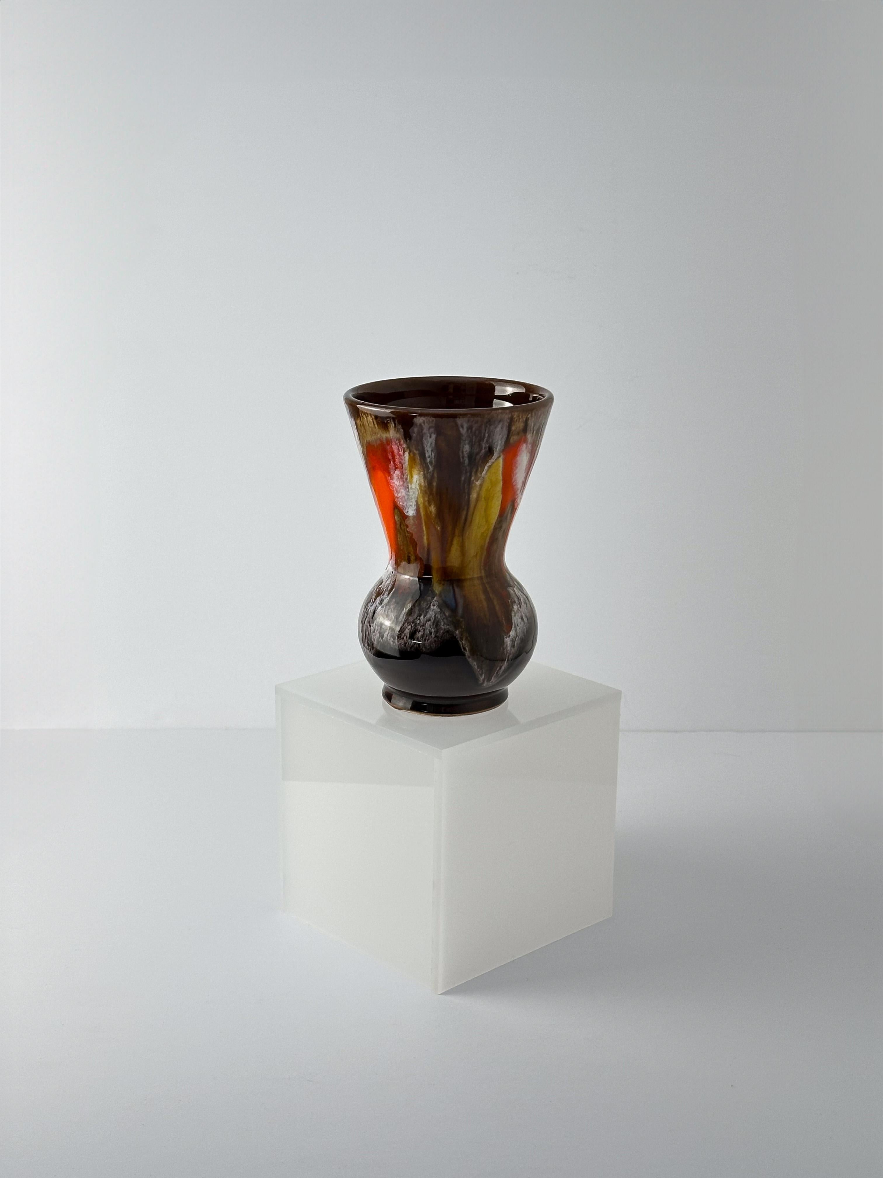 A small modernist-style vase, handcrafted in Vallauris, France, circa 1960s 

Simple and modernist in form, the vase features a rotund base that expands into a sharply angular, inverted truncated cone. The ceramic is glazed in a warm, deep brown,
