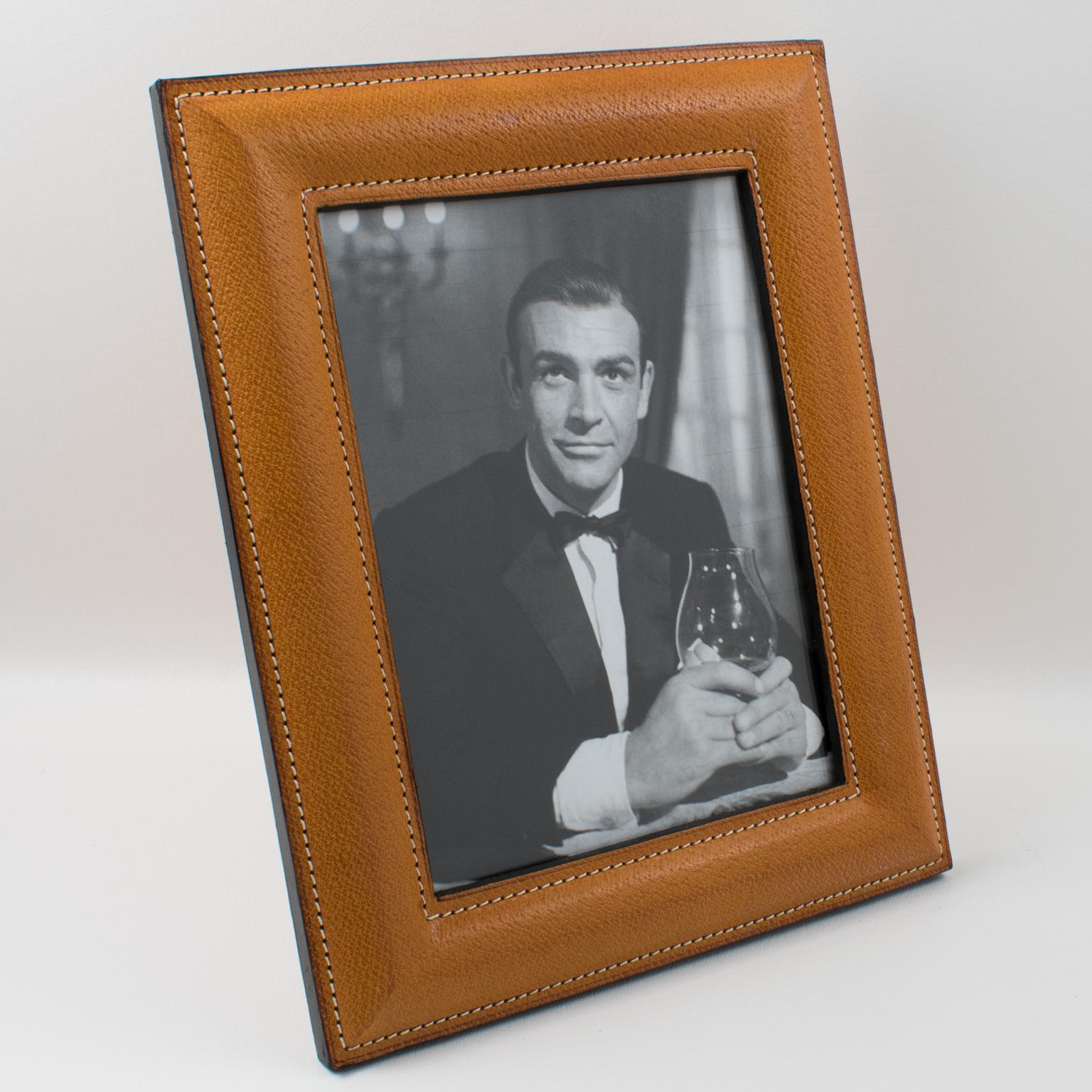 Sophisticated 1950s modernist leather picture photo frame by Valstar, Milano. Natural light cognac leather with a pattern, hand-stitched finish, and black edges. Easel and back in the same cognac leather and glass protection on the front. The frame