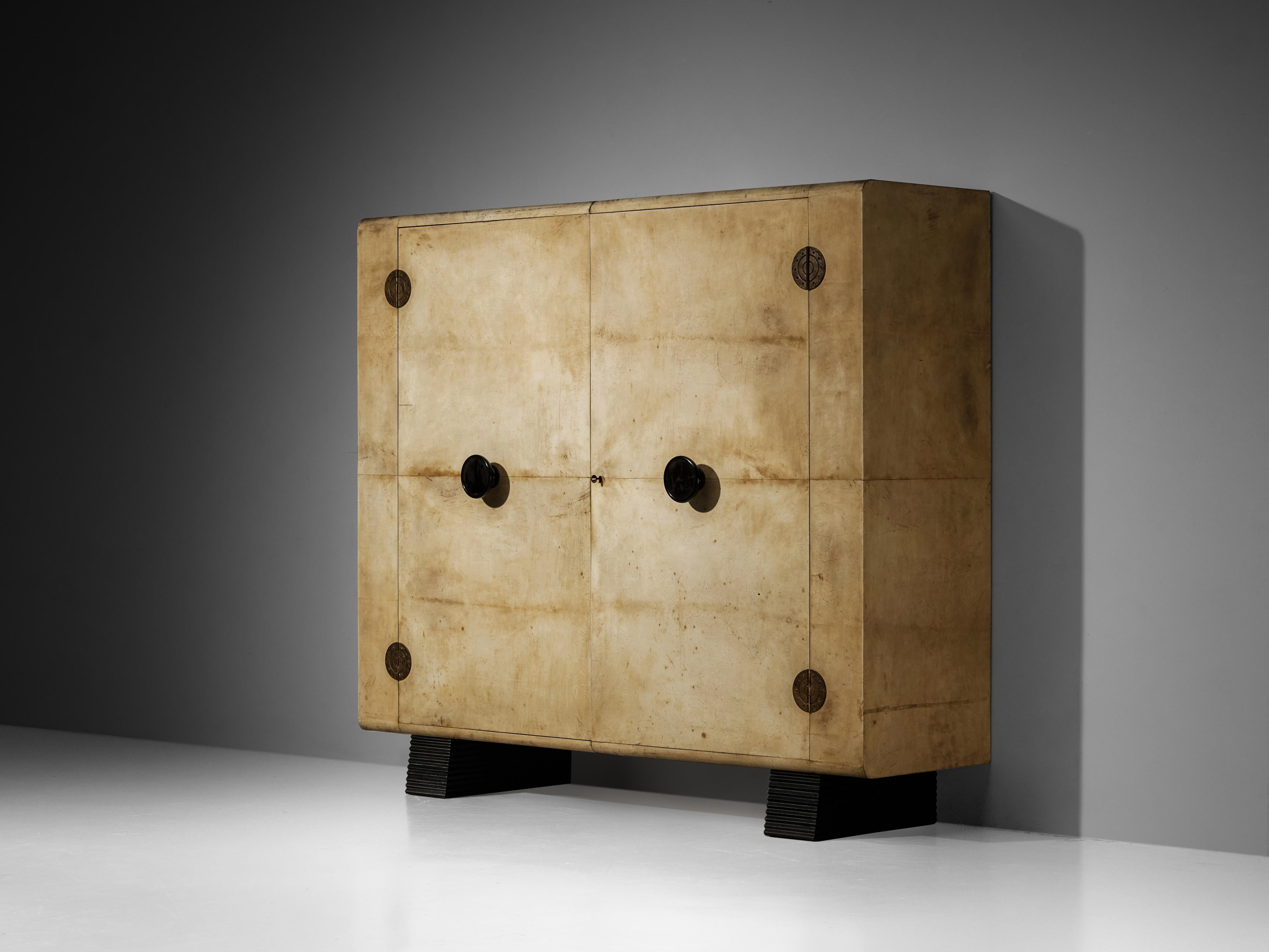 Valzania, armario, pergamino de piel de cabra, latón, madera lacada, haya, arce, metal, Italia, años 30

Remontándose a los glamurosos años 30, una época marcada por el florecimiento del Art Déco en el diseño de muebles, este exquisito armario de