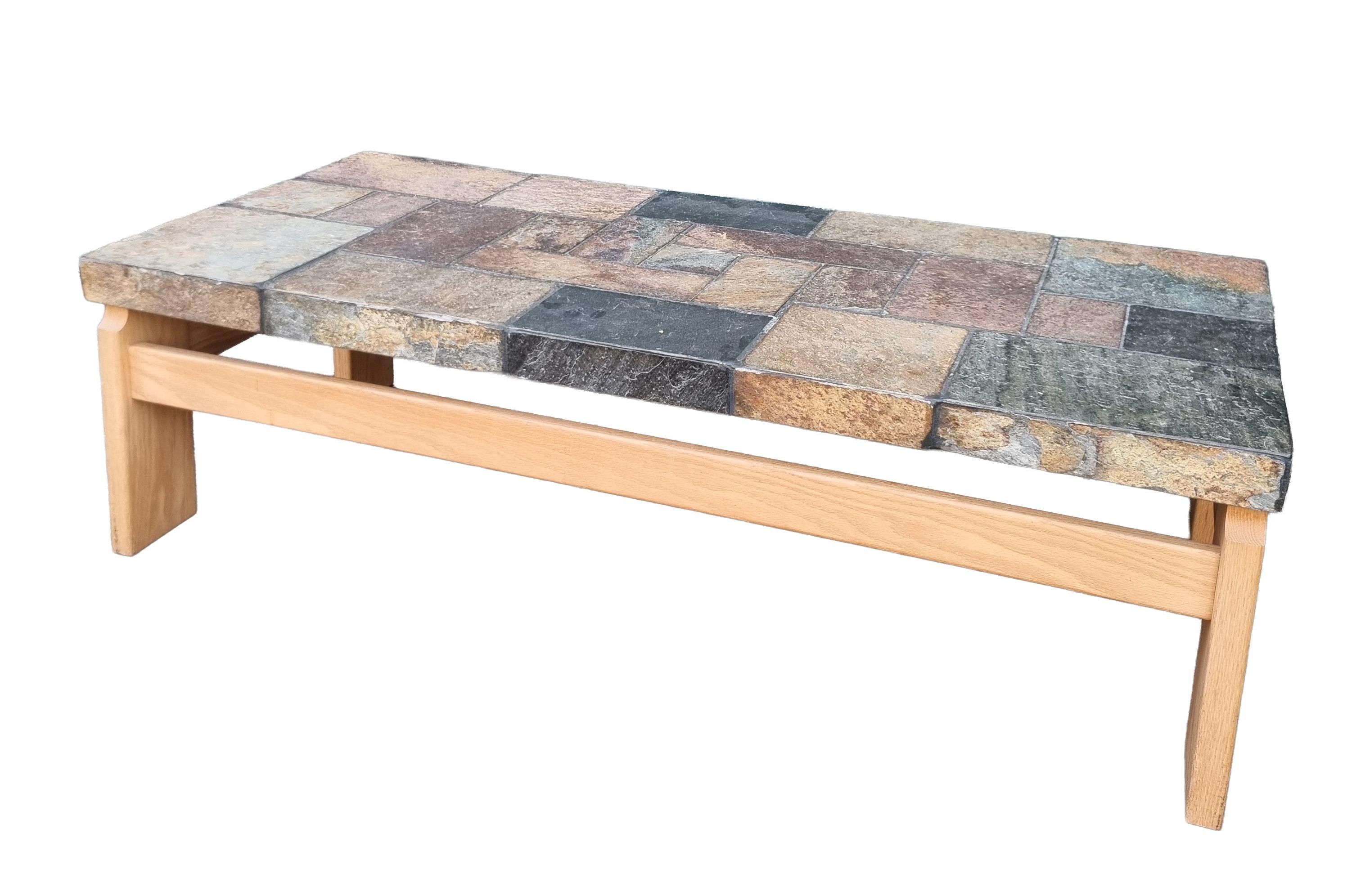 Évoquant les tables sculpturales en ardoise associées à Paul Kingma, cette table basse en pierre mélangée a été produite aux Pays-Bas par Van Bennekom's Meubelfabriek, vers les années 1970. Le plateau substantiel est composé de morceaux d'ardoise