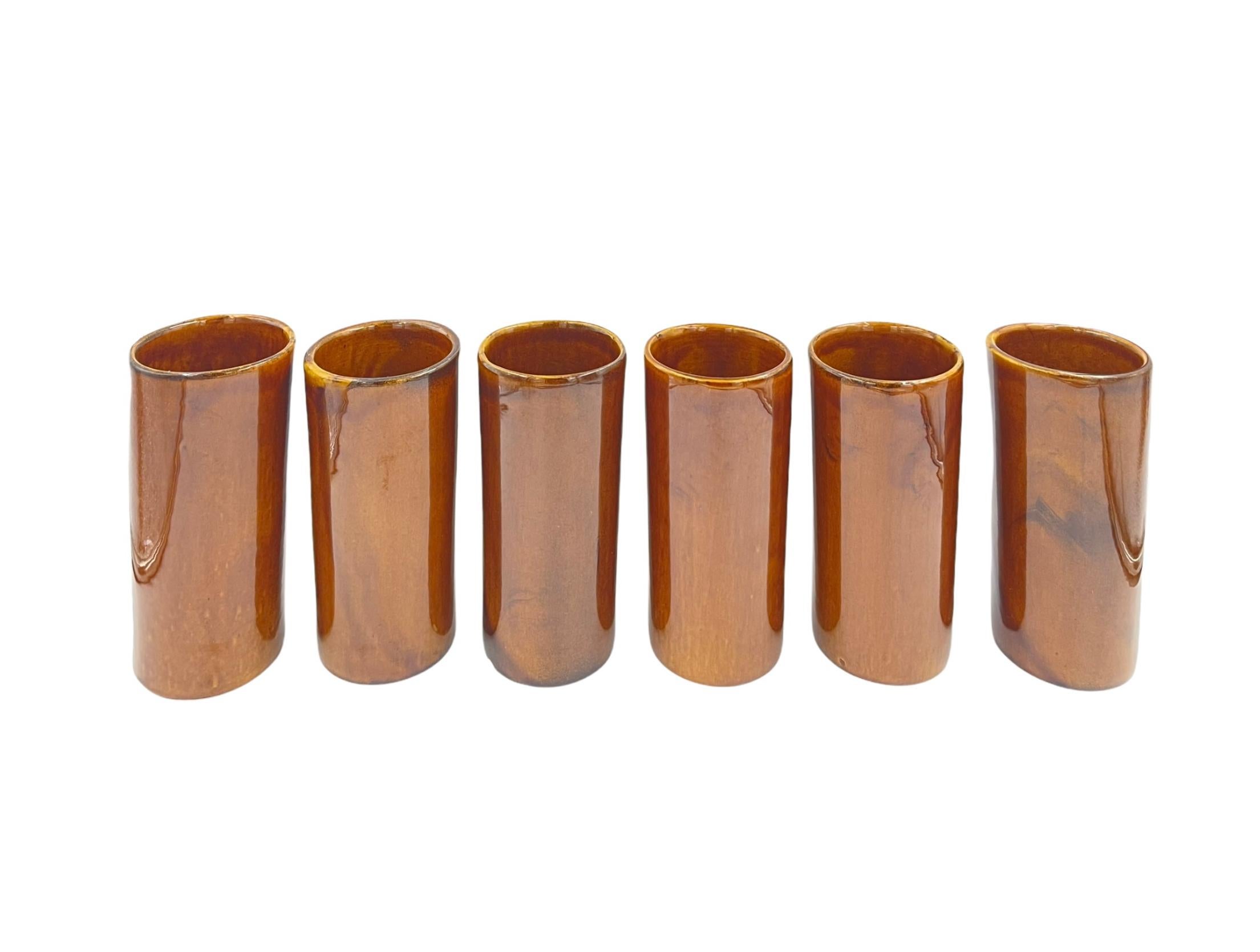 Brown ceramic vessels by Van Briggle of Colorado Springs, Colorado. Could be used as drinking glasses, or as vases for centerpiece decor. 
Measures: 6” height x 2.75” diameter

Van Briggle Art Pottery was at the time of its demise the oldest