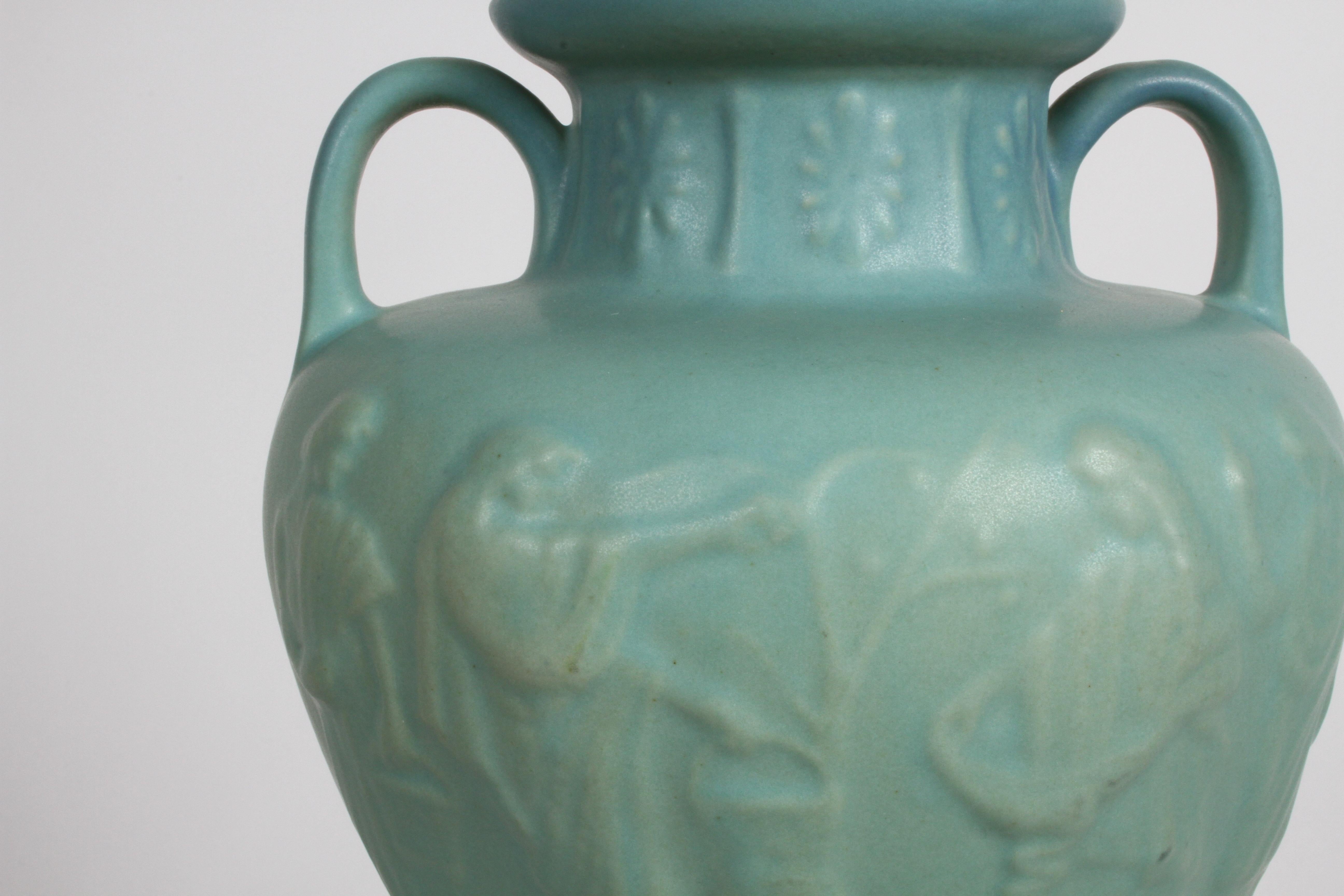 Van Briggle-Urne im griechischen Stil aus den 1980er Jahren mit türkisfarbener Ming-Glasur, signiert von der Töpferin Dorothy Ruff (D.R.). Die Urne hat eine hohe Schulter mit Schlaufengriffen, Figuren in Flachrelief am Umfang und ein florales Muster