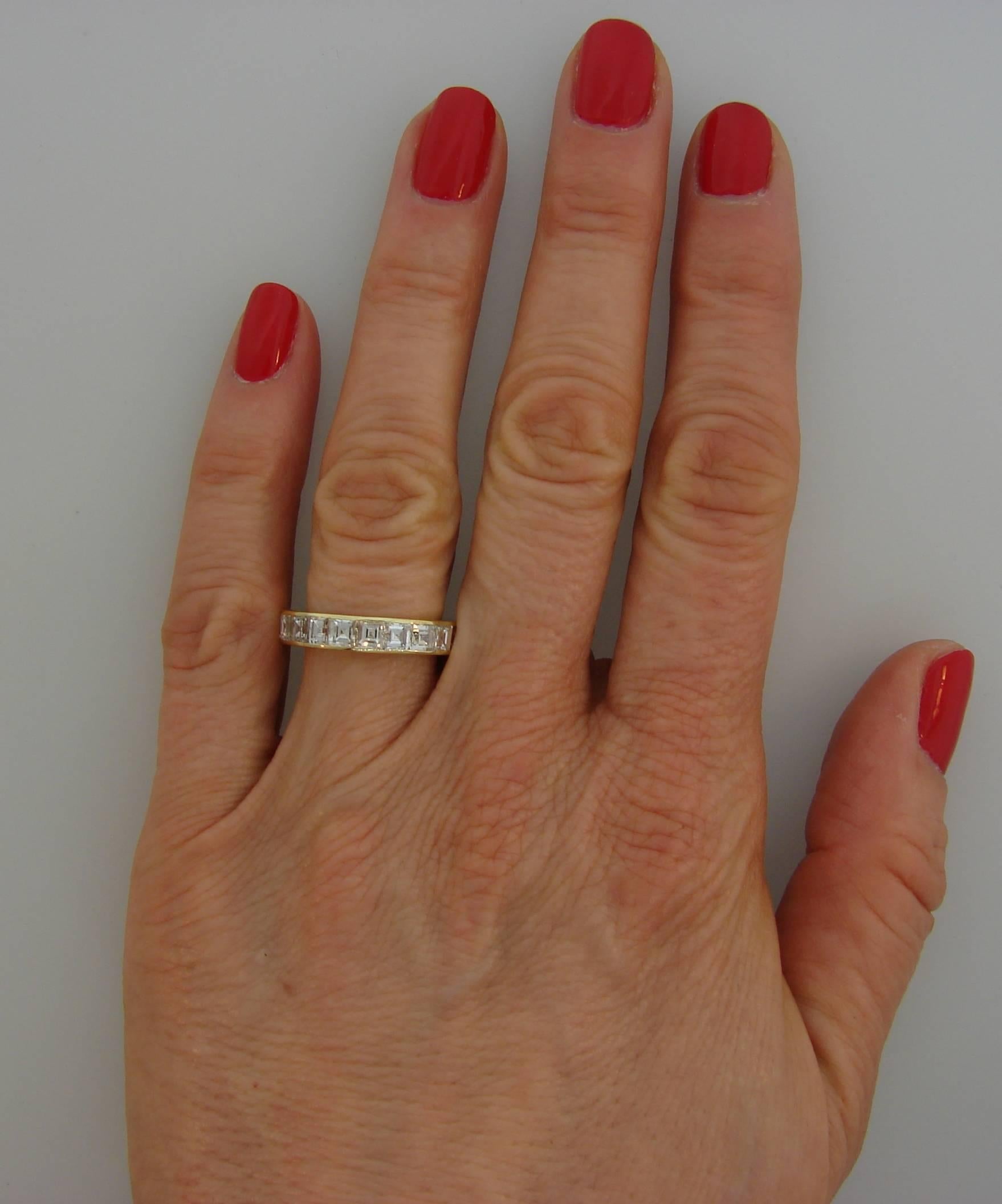 Classy and timeless eternity band created by Van Cleef & Arpels. 
It is made of 18 karat yellow gold and twenty one asscher cut diamonds (F color, VVS clarity, total weight approximately 4.20 carats). 
The band is size 6.75-7. It is 4.2 mm wide and
