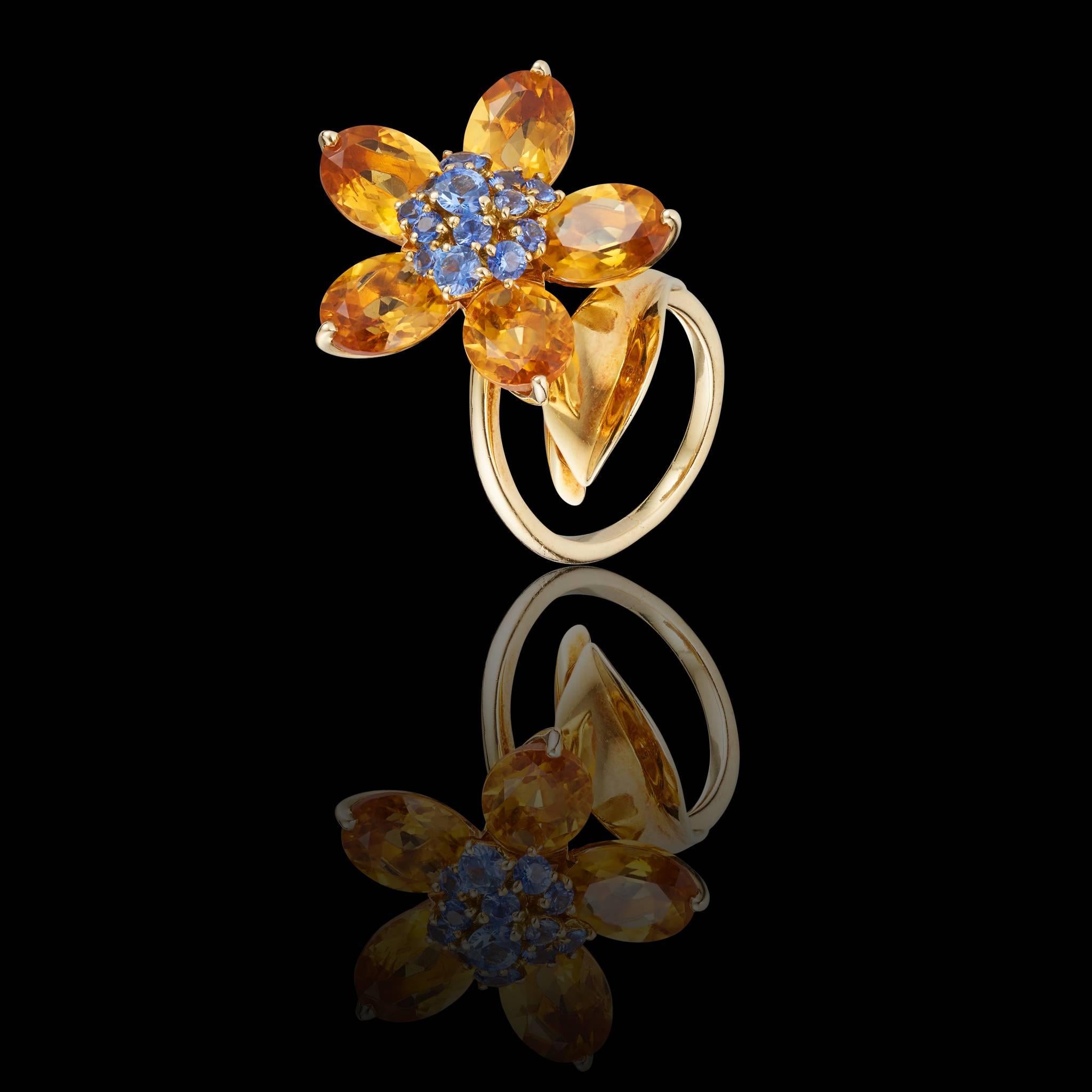 Van Cleef & Arpels sapphires and citrines ring made in 18k gold featuring an open band accented with a leaf and rotatable flower made of 5 faceted citrines petals and a cluster of faceted blue