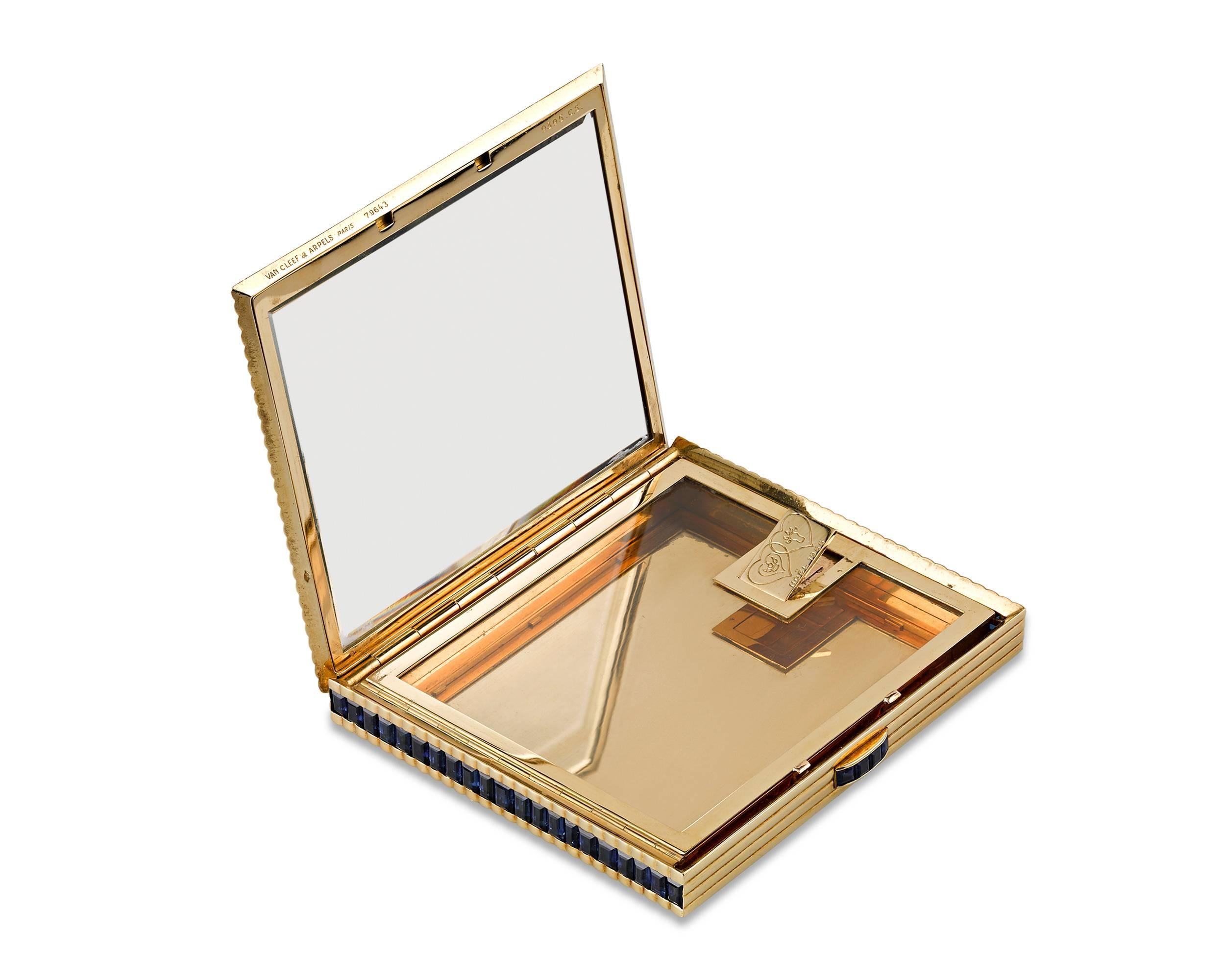 This exquisite compact was created by the famed French jewelry firm of Van Cleef & Arpels. The body of the case is crafted of 18K yellow gold, while dramatic blue sapphires accent the clasp and each side. Opening the case reveals a mirrored lid and