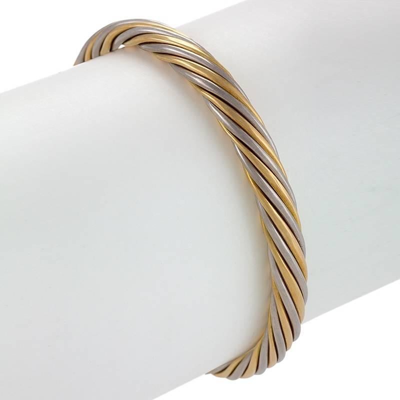 A French 18 karat gold bangle bracelets by Van Cleef & Arpels. The polished yellow and white gold bracelet is designed in a multi-strand twisted motif.  Circa 1970-80's.

Signed, 