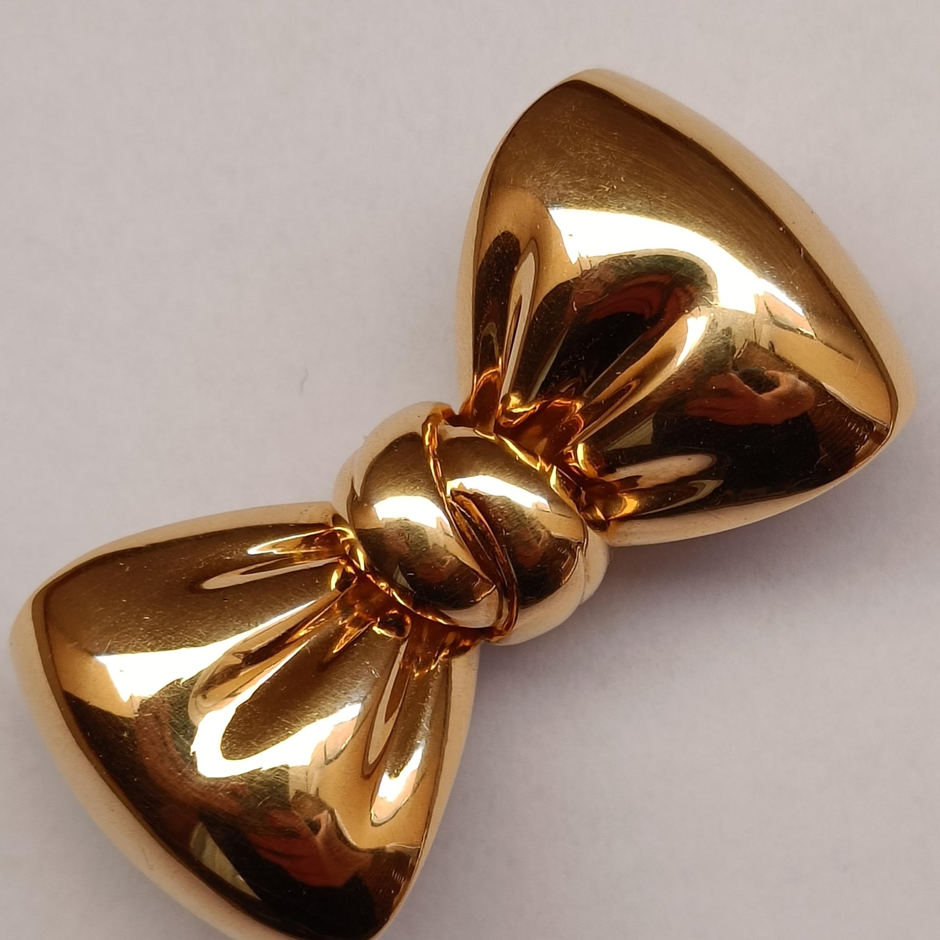 Van Cleef & Arpels, a bold and chunky clip brooch designed as a bow crafted in 18k yellow gold.

Stamped VCA 750 and serial number.
Good condition, no defects.

Dimensions: 4 x 2 cm (approx.)
Weight 26.40 grams

Original pouch included, signed Van