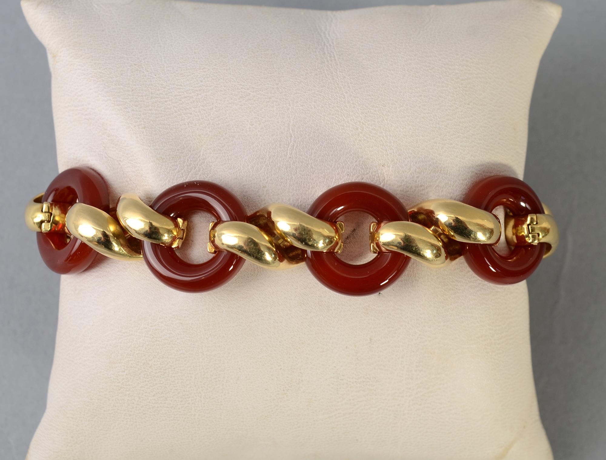 Van Cleef and Arpels  bracelet of 18 karat gold and carnelian. Gold figure eight links alternate with open circles of carnelian.  The clasp is beautifully incorporated into one of the gold links. Were it not for the safety catch, it would be