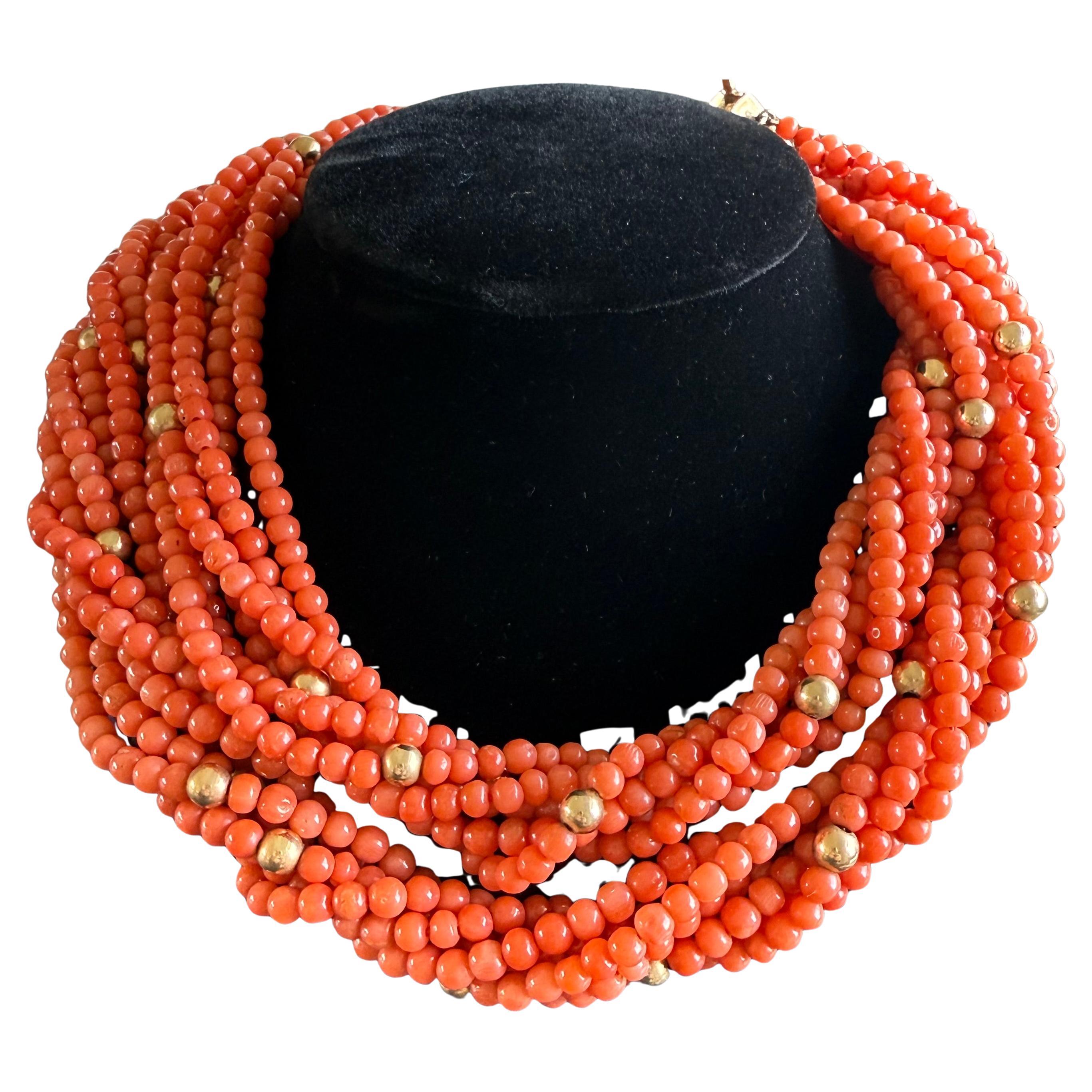 Questa collana di Van Cleef & Arpels è un pezzo straordinario composto da 12 fili di perle di corallo, ciascuno con un diametro di circa 4,5 mm e una lunghezza di 24 pollici. La collana presenta 38 distanziatori a sfera in oro e una chiusura a