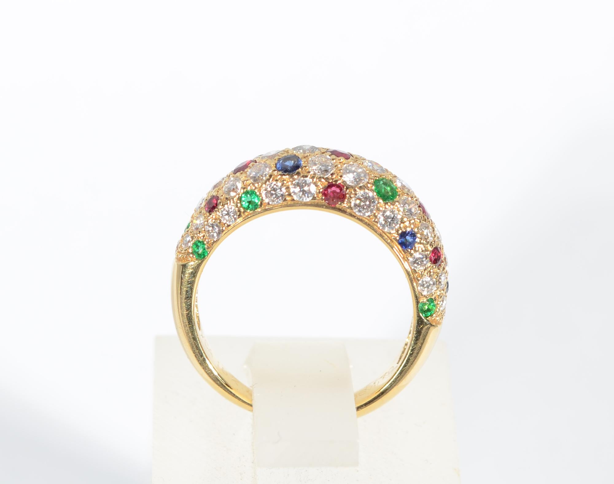 Elegant diamond band ring interspersed with rubies; sapphires and emeralds by the premier jewelry house, Van Cleef and Arpels. The ring measures 1/4