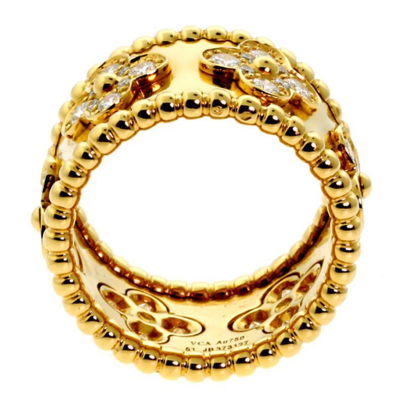 Van Cleef & Arpels perlee diamond gold ring is an elegant wide eternity band, finely crafted in solid 18k yellow gold. Tiny classic Alhambra motif designs, adorned with .48ct appx fine round brilliant cut diamonds, are inlaid around the entire
