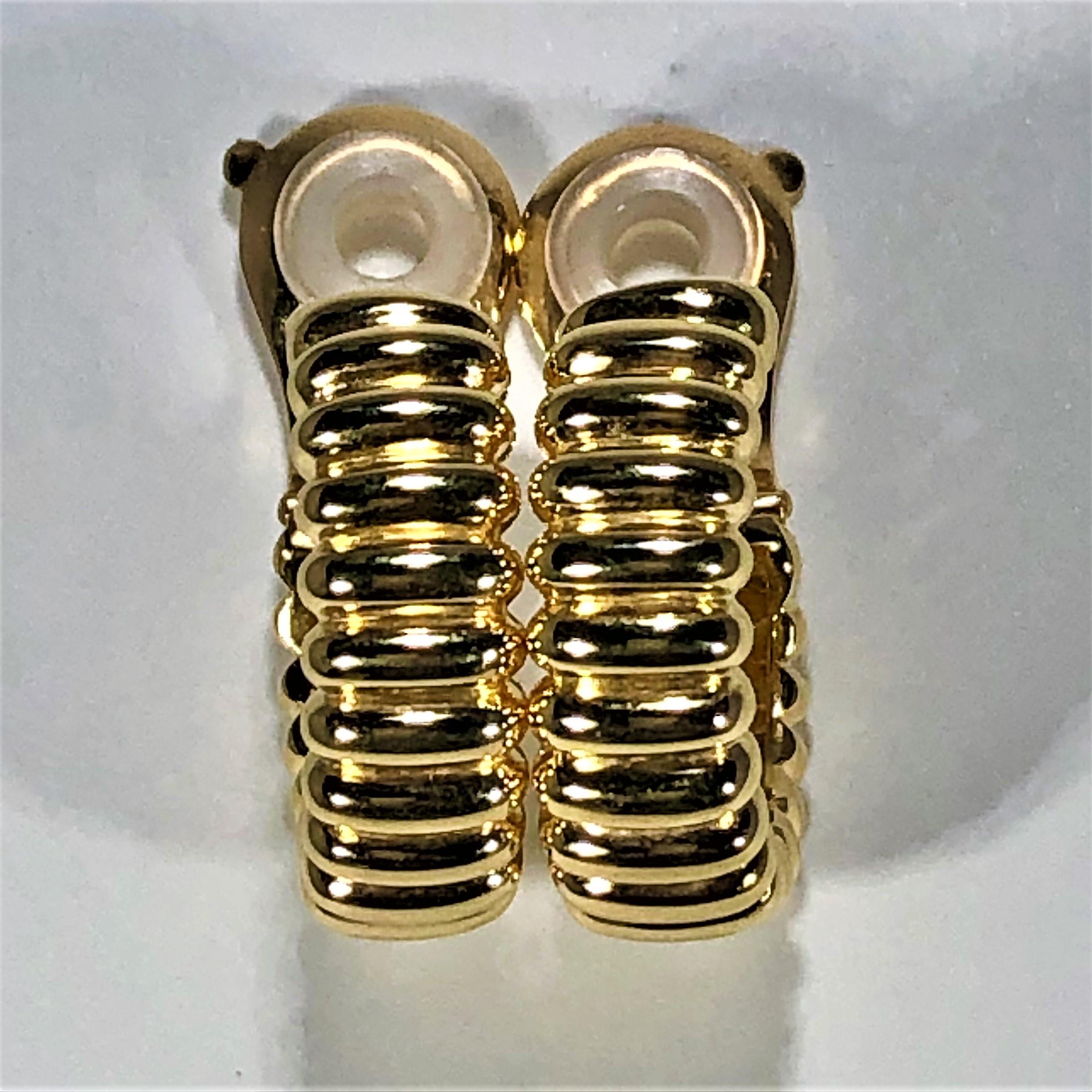 A pair of 18K yellow gold earrings that would be right at home with a tubogas collection, due to its corrugated appearance. Designed by Van Cleef & Arpels, they measure 7/8 of an inch long, and 5/16 of an inch wide, and have a beautiful high polish
