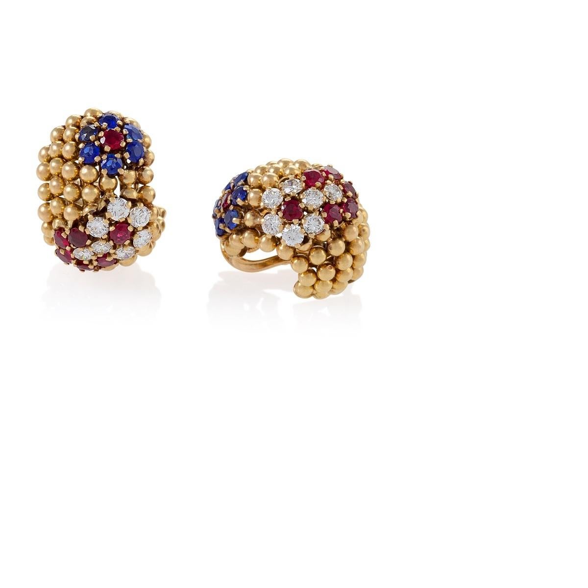 A pair of French Mid-20th Century 18 karat gold ear clips by Van Cleef and Arpels with diamonds, rubies and sapphires. The 12 round-cut diamonds have the approximate total weight of 1.68 carats and the approximate total weight of the 24 round