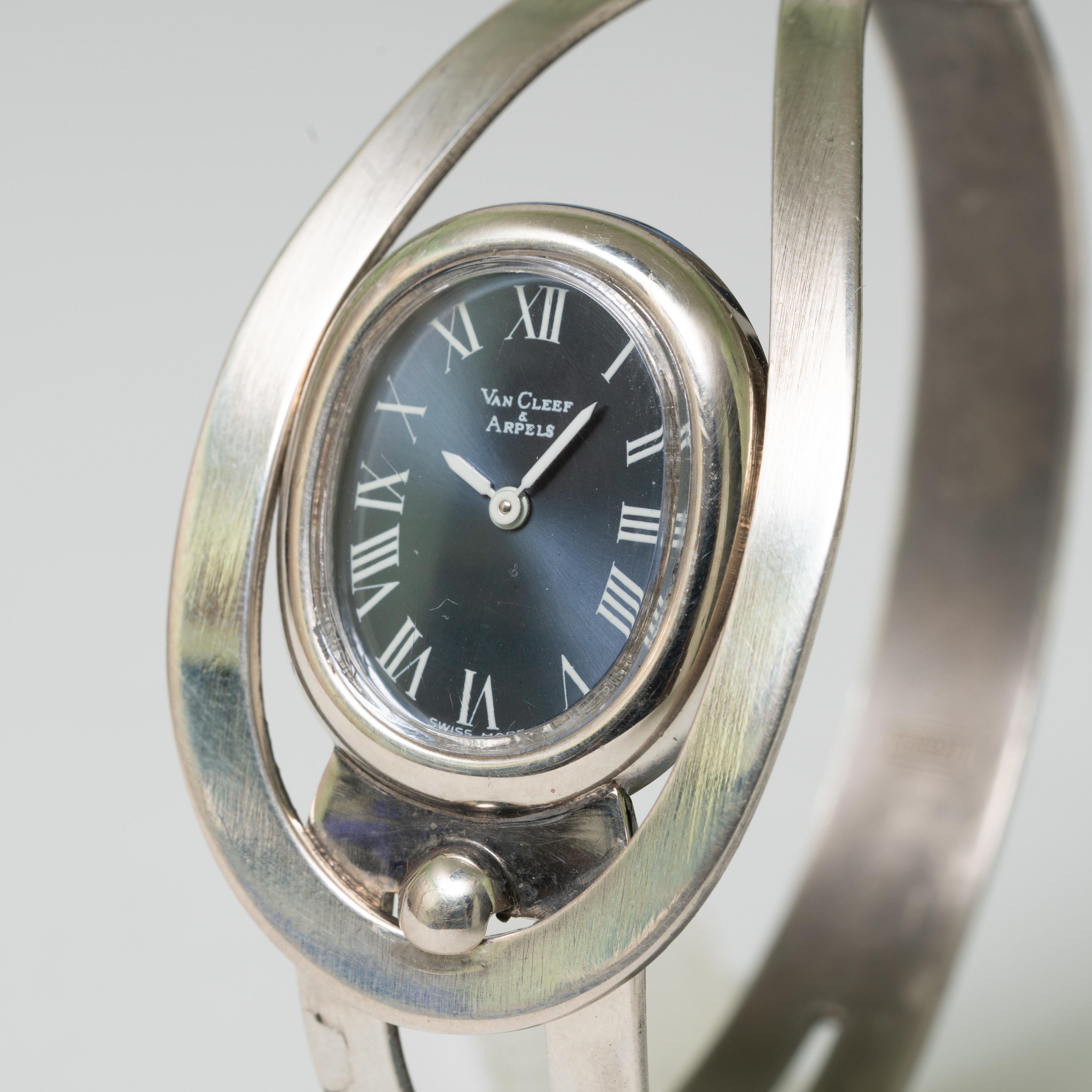Van Cleef and Arpels wristwatch. Radial brushed midnight blue dial, Roman numerals with White pencil type minute/hour hands. Unique two piece fold over bracelet, with exposed fixed closure. Made for Van Cleef and Arpels by the Concord Watch company.