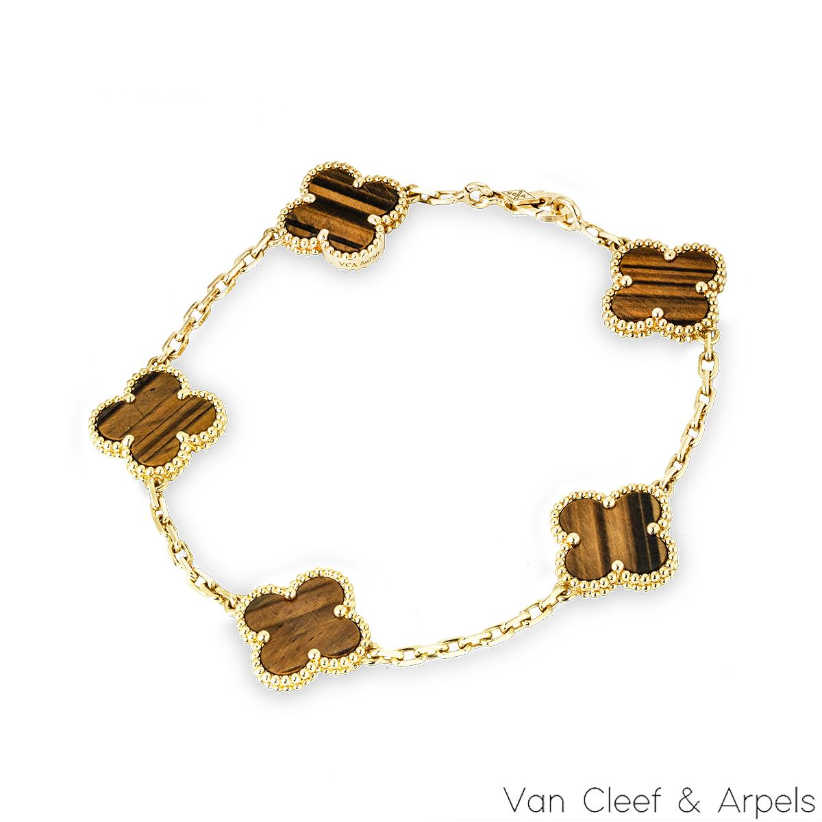 Bracciale in oro giallo 18 carati della collezione Vintage Alhambra di Van Cleef and Arpels. Il braccialetto è composto da 5 iconici motivi a trifoglio, ognuno dei quali è incastonato con un bordo di perline e un intarsio di occhio di tigre,