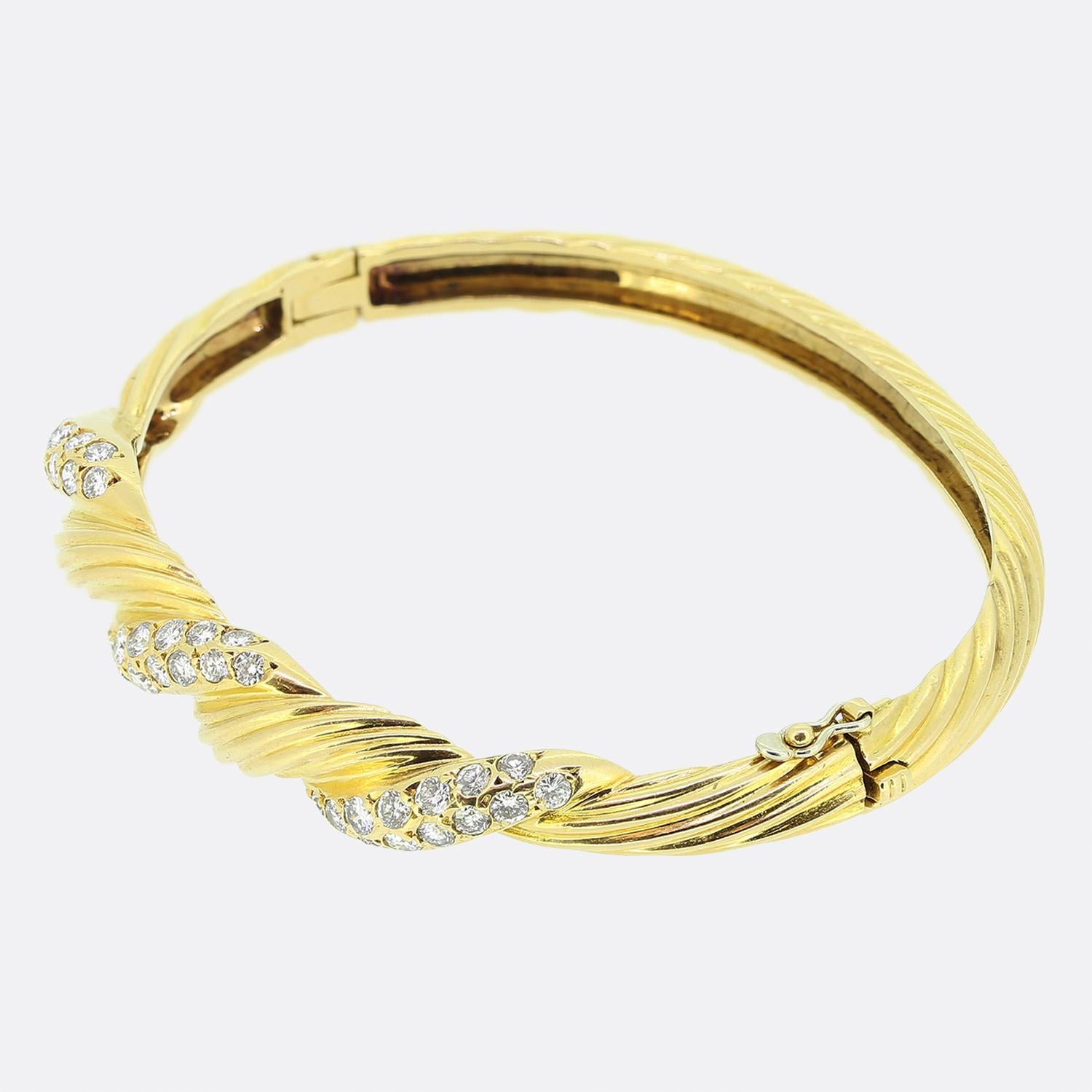 Here we have a wonderful diamond bracelet from the world renowned jewellery designer Van Cleef and Arpels. The bangle features 1.50 carats of perfectly matched round brilliant cut diamonds that are set in a twisted design. The bangle is marked VCA