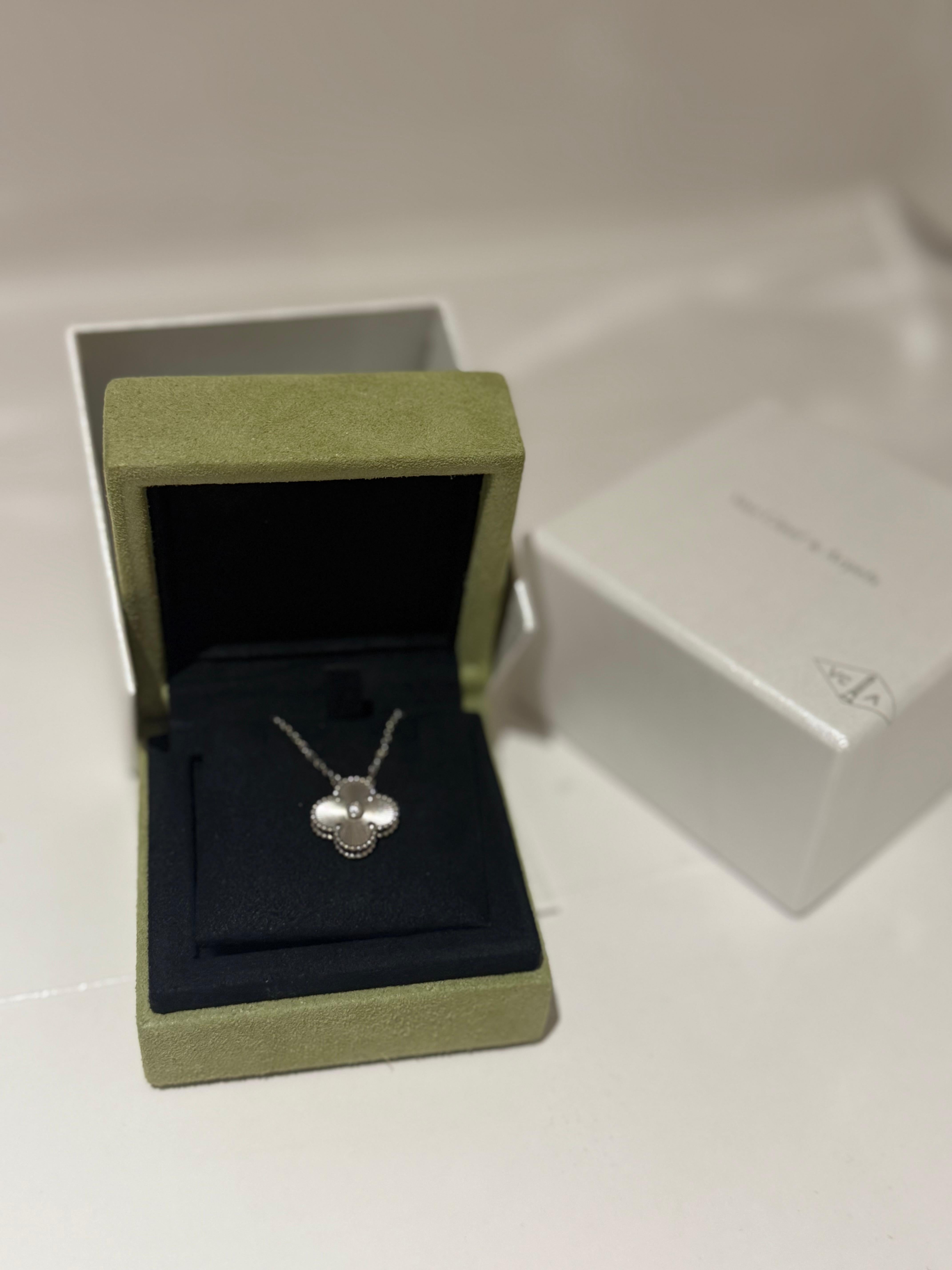  
A Van Cleef & Arpels limited edition 18k white gold Guilloche and diamond  Vintage Alhambra pendant from the 2020 Holiday pendant collection. The pendant features a beaded edge 4 leaf clover motif with a white gold guilloche inlay. Further